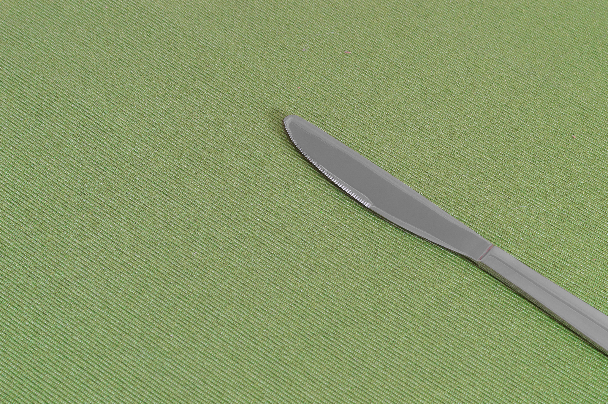 one knife on a green sheet with copy space