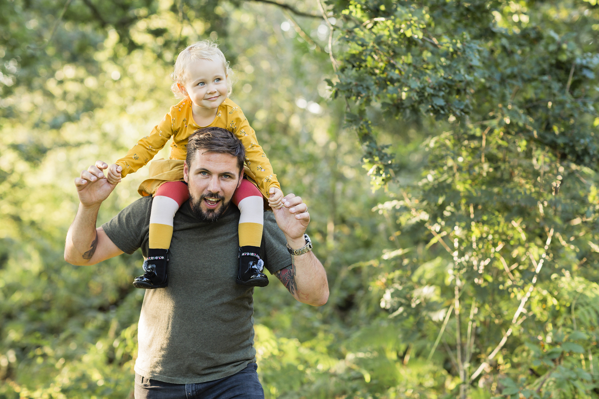 mature man playing with his little daughter in nature