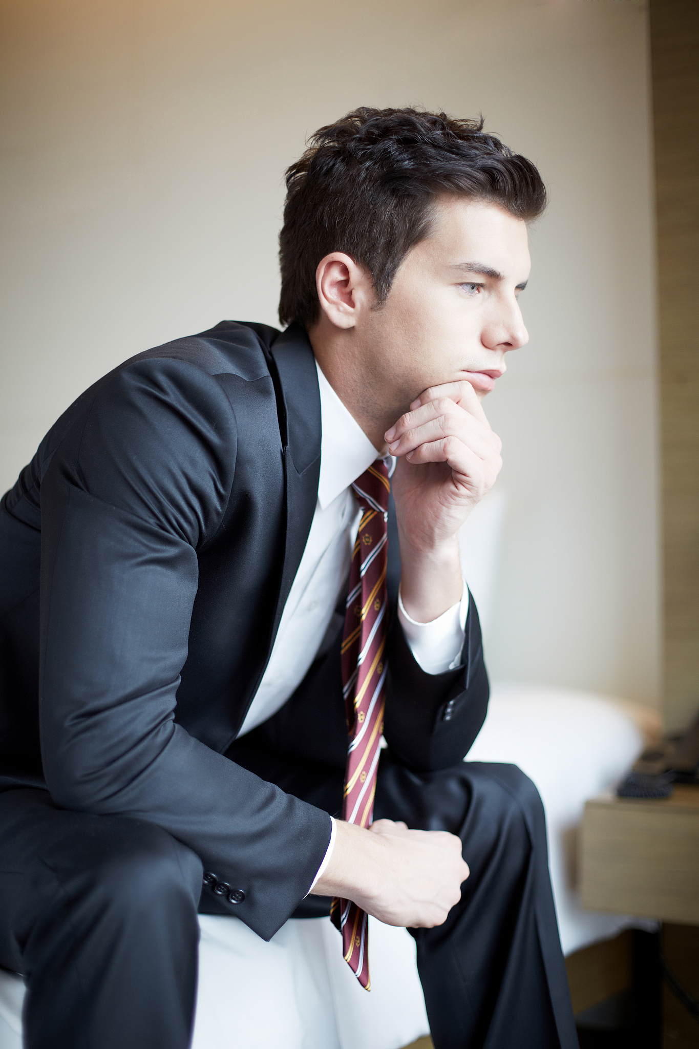 photography of businessman sitting on the bed thinking