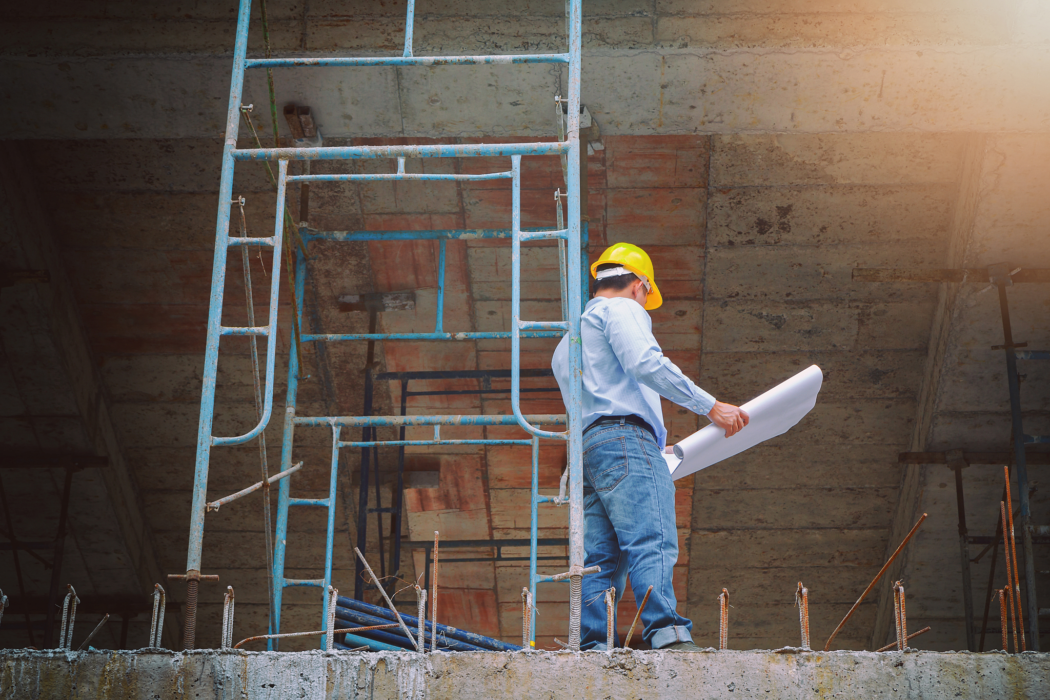 engineer with blueprint in building construction site