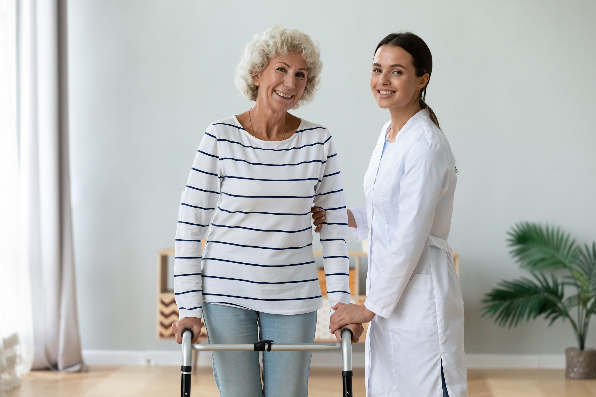 elderly woman holding rollator feels satisfied after therapy wit