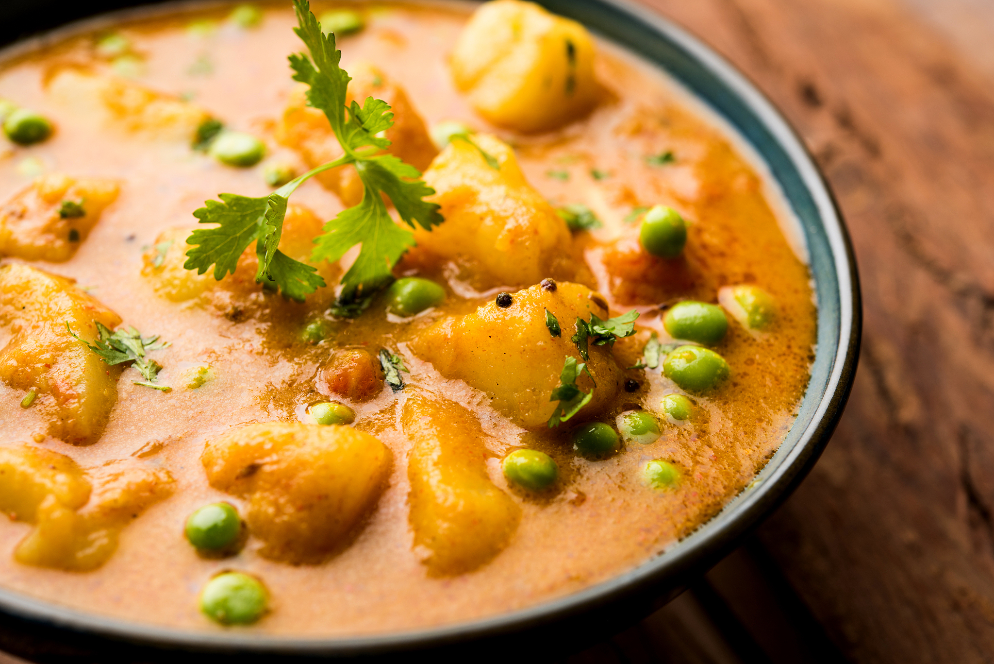 indian aloo mutter curry - potato and peas immersed in an onion 