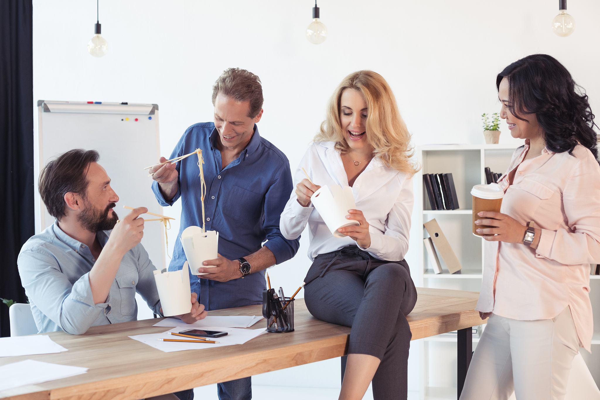 smiling middle aged businessmen and businesswomen eating asian f