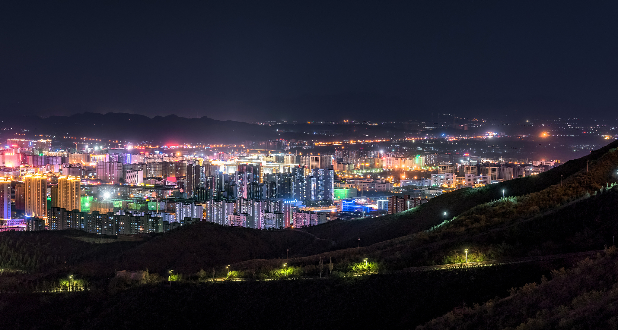 view of neon signs and traffic in zhangjiakou at night, hebei, c