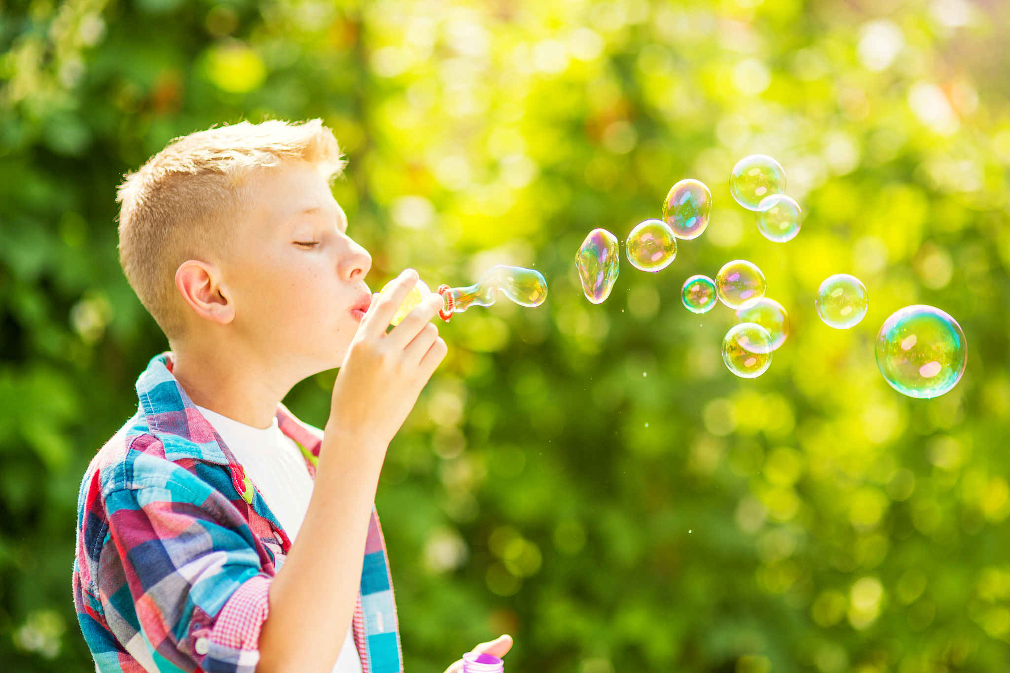 portrait of a young boy blowing soap bubbles