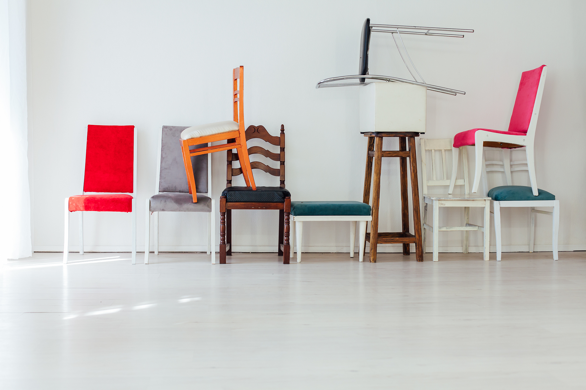 different multicolored chairs in the interior of the white room