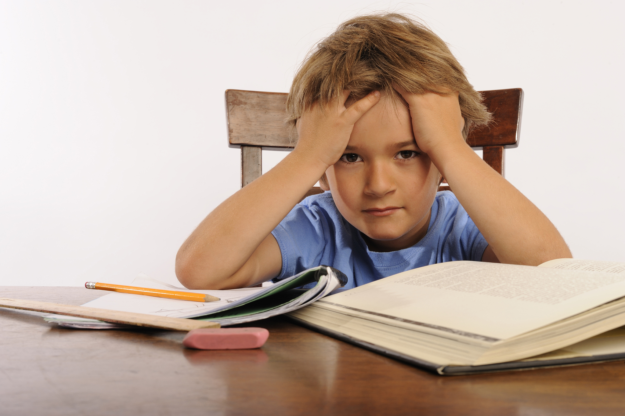 school-aged boy getting frustrated with homework at table