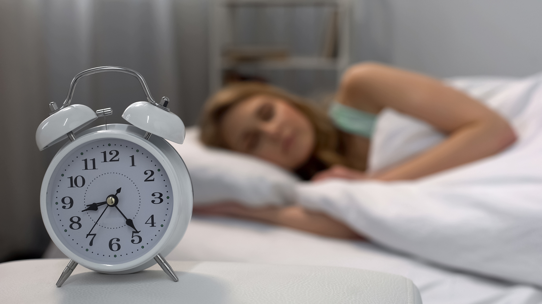 woman oversleeping in morning, alarm clock ringing near bed, dai
