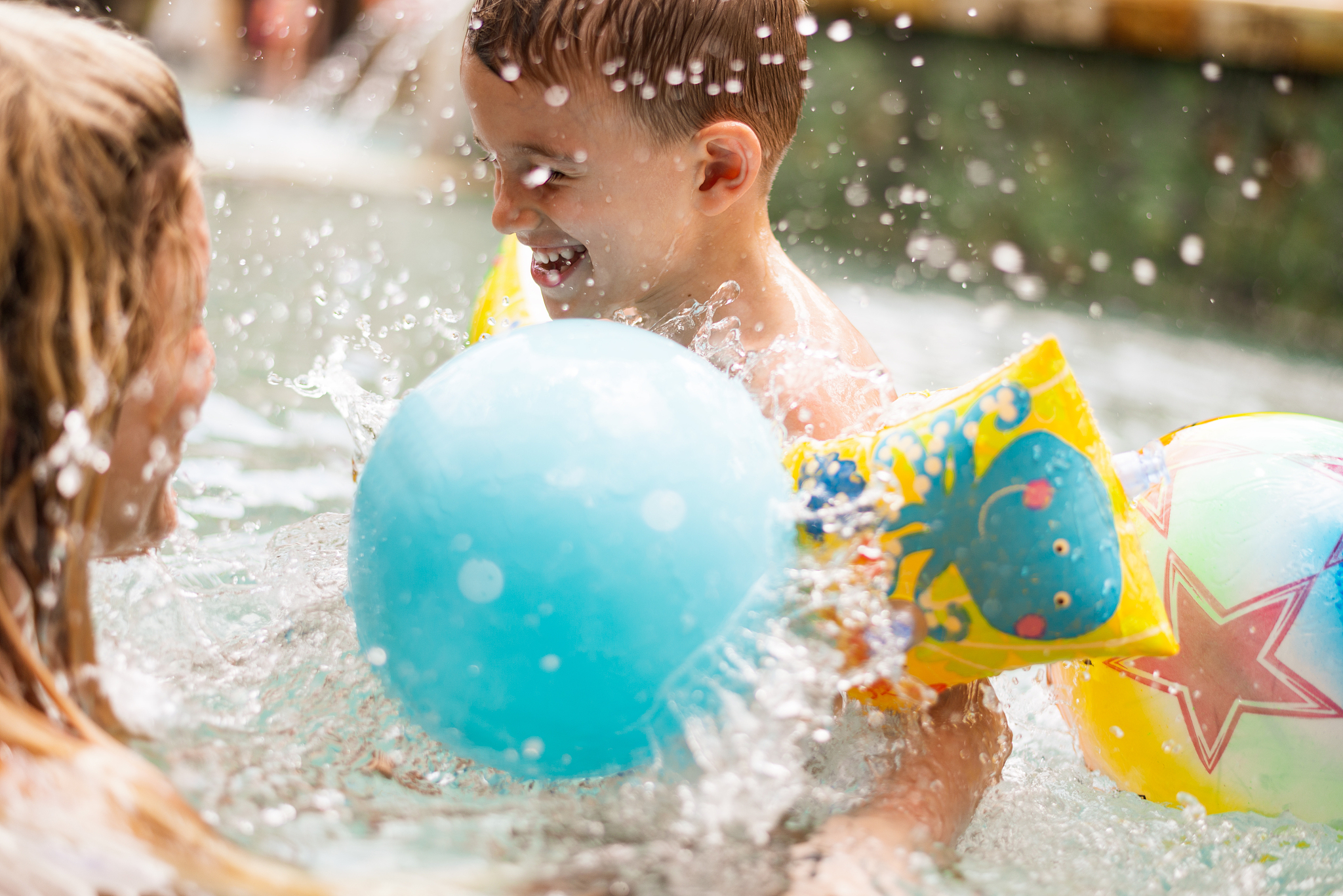 happy little boy having fun in the swimming pool with his mother