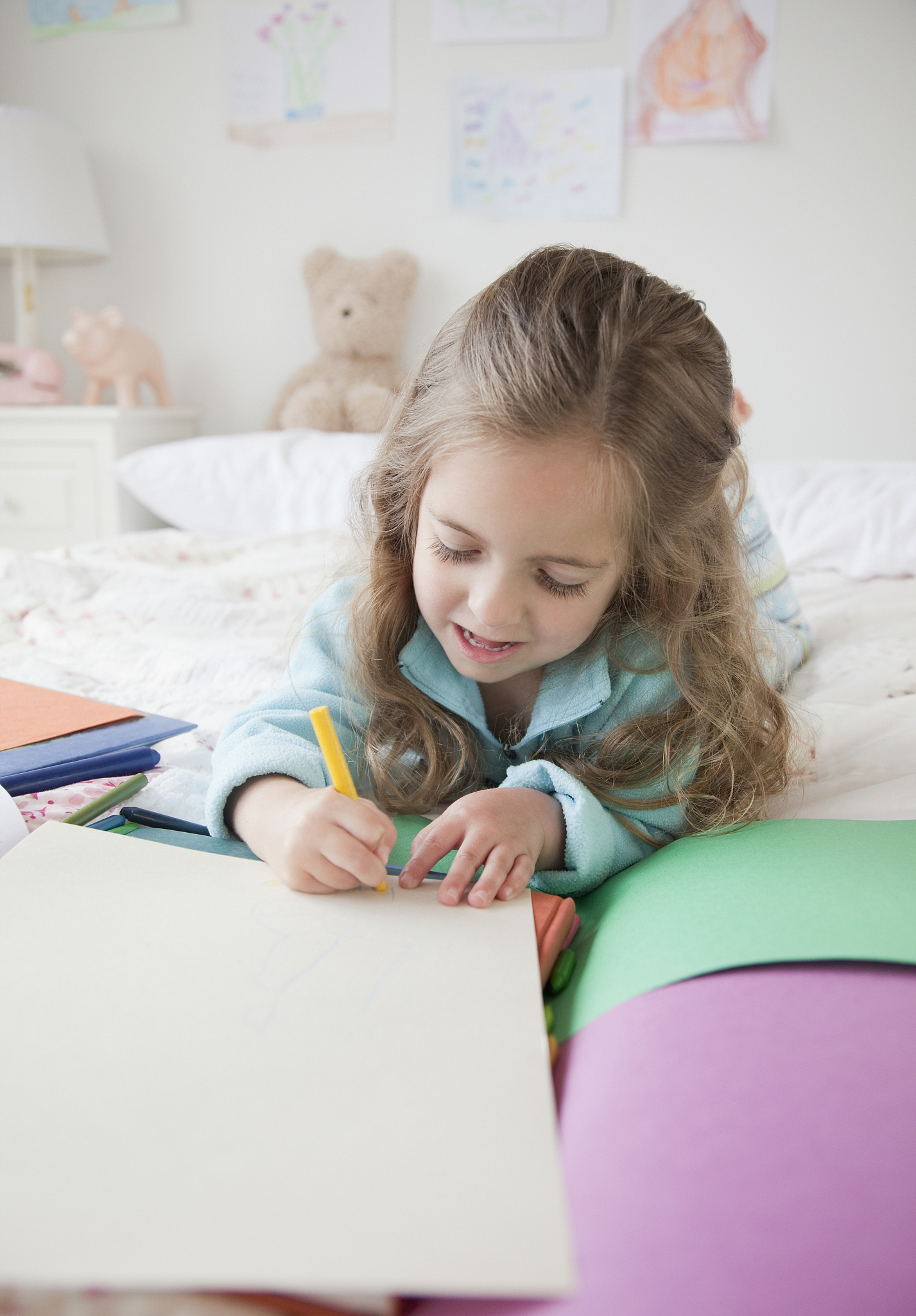 young girl coloring in bedroom