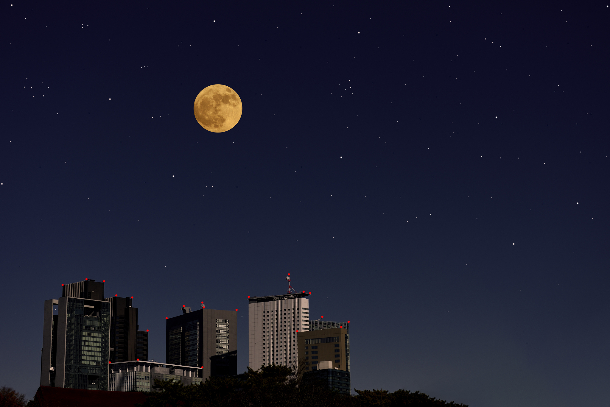 full moon rising over the skyscrapers and lots of stars