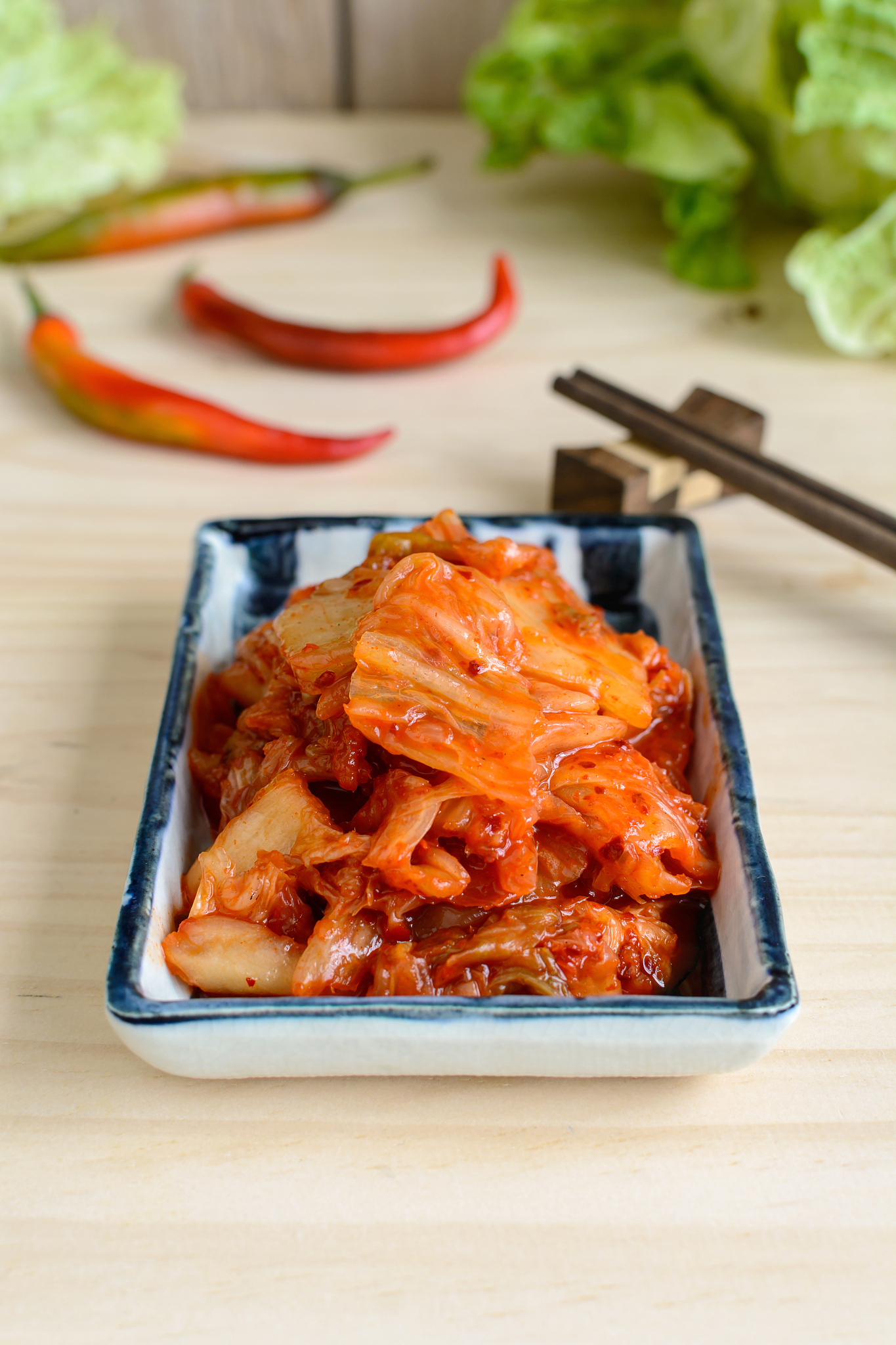 kimchi with chopsticks on wooden table, korean traditional food