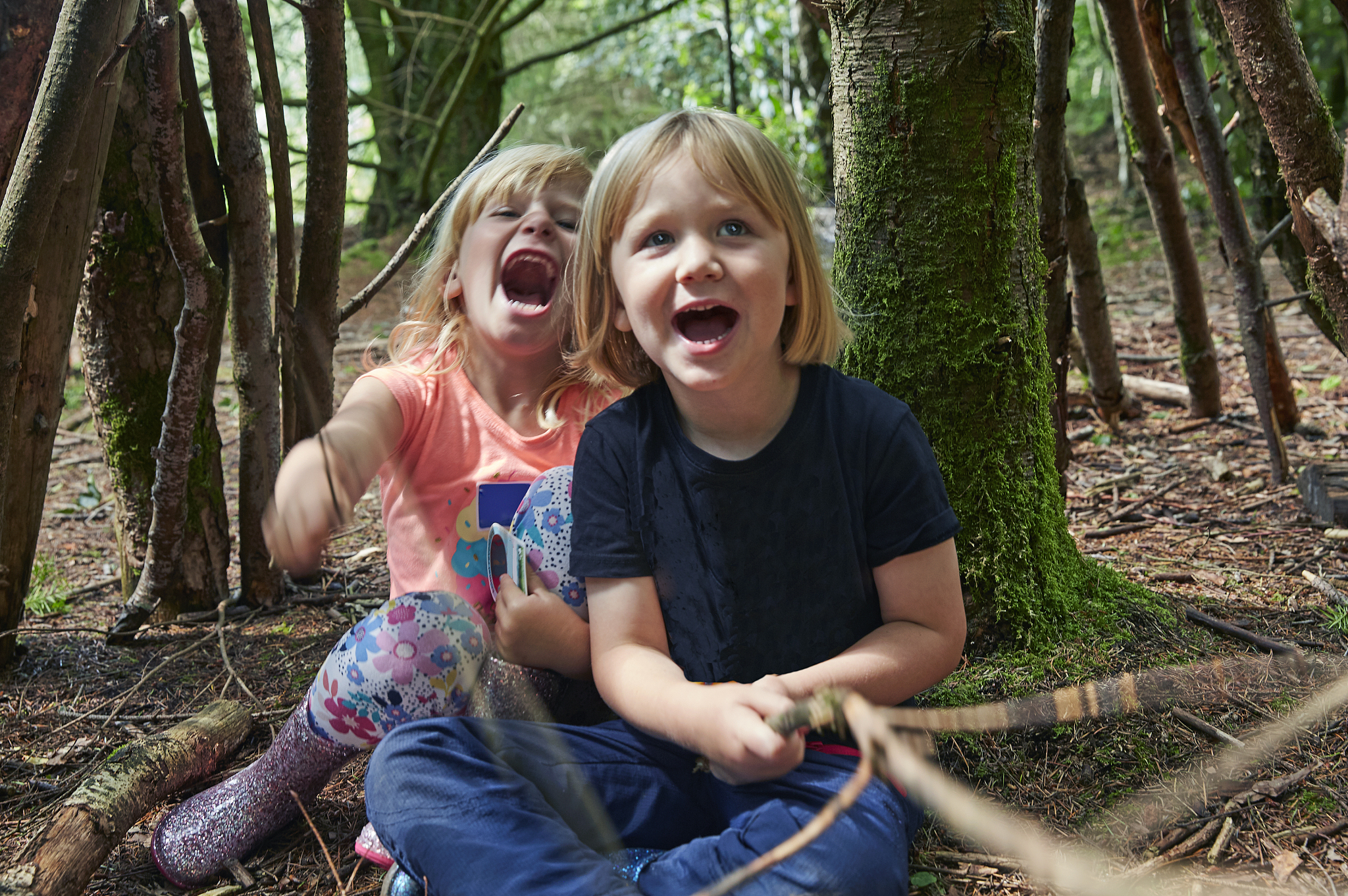 two 4 year olds playing in forest in uk
