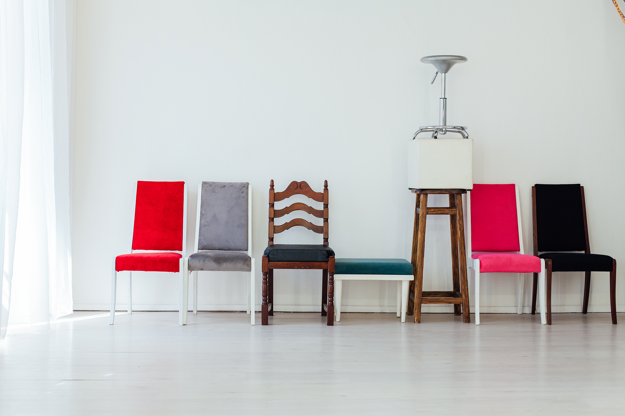 nine chairs in an empty white interior room