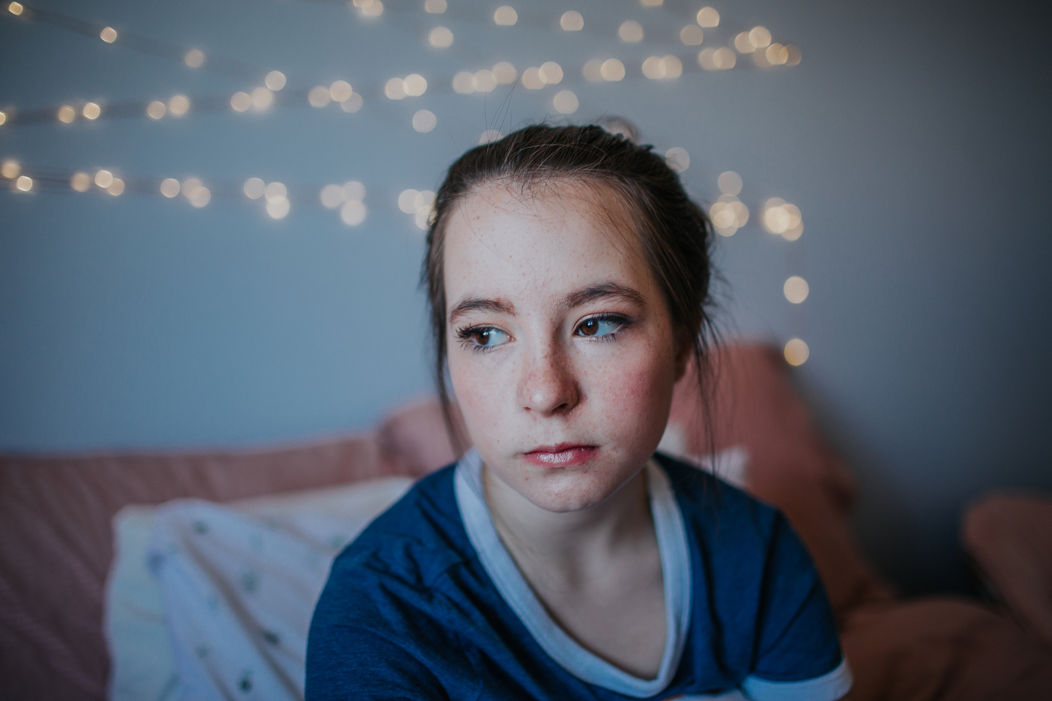 content tween sitting on bed looking out window