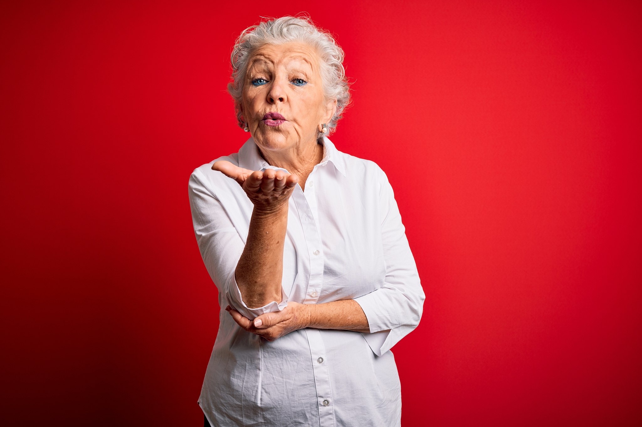 senior beautiful woman wearing elegant shirt standing over isola