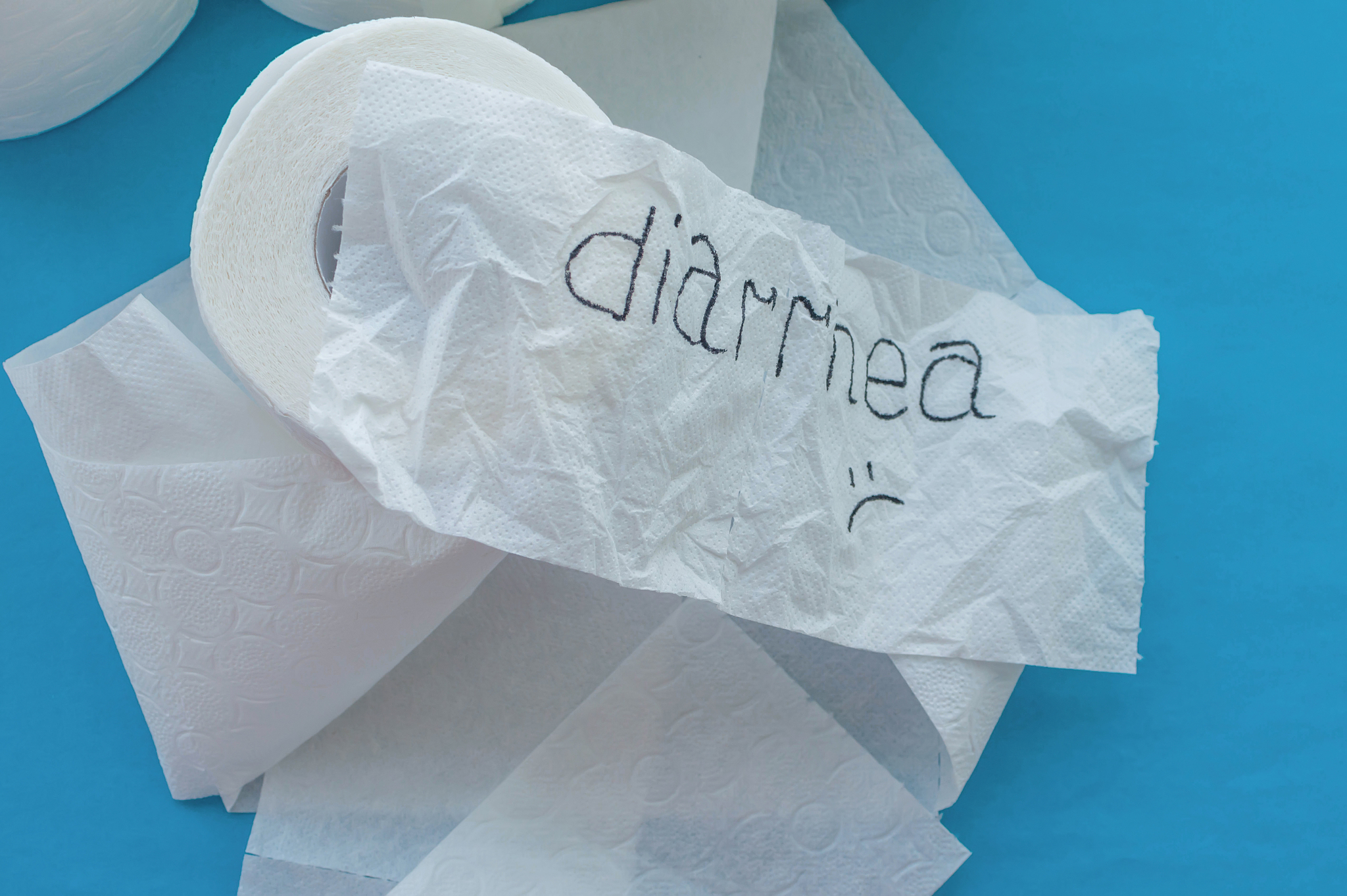 rolls of white toilet paper labeled "diarrhea" on a blue backgro