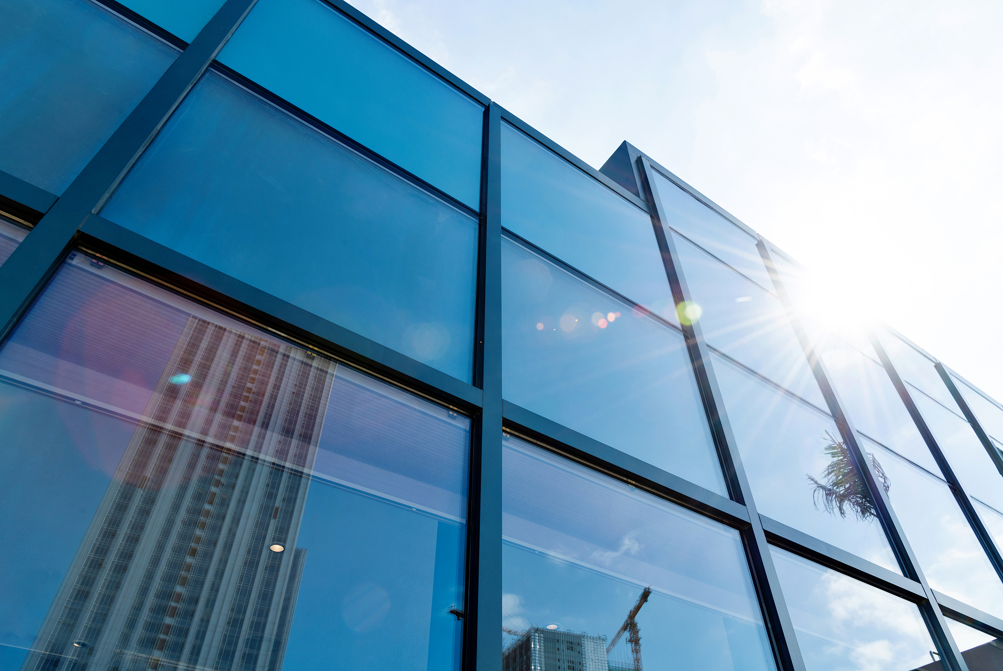 construction site reflected on glass windows of modern building
