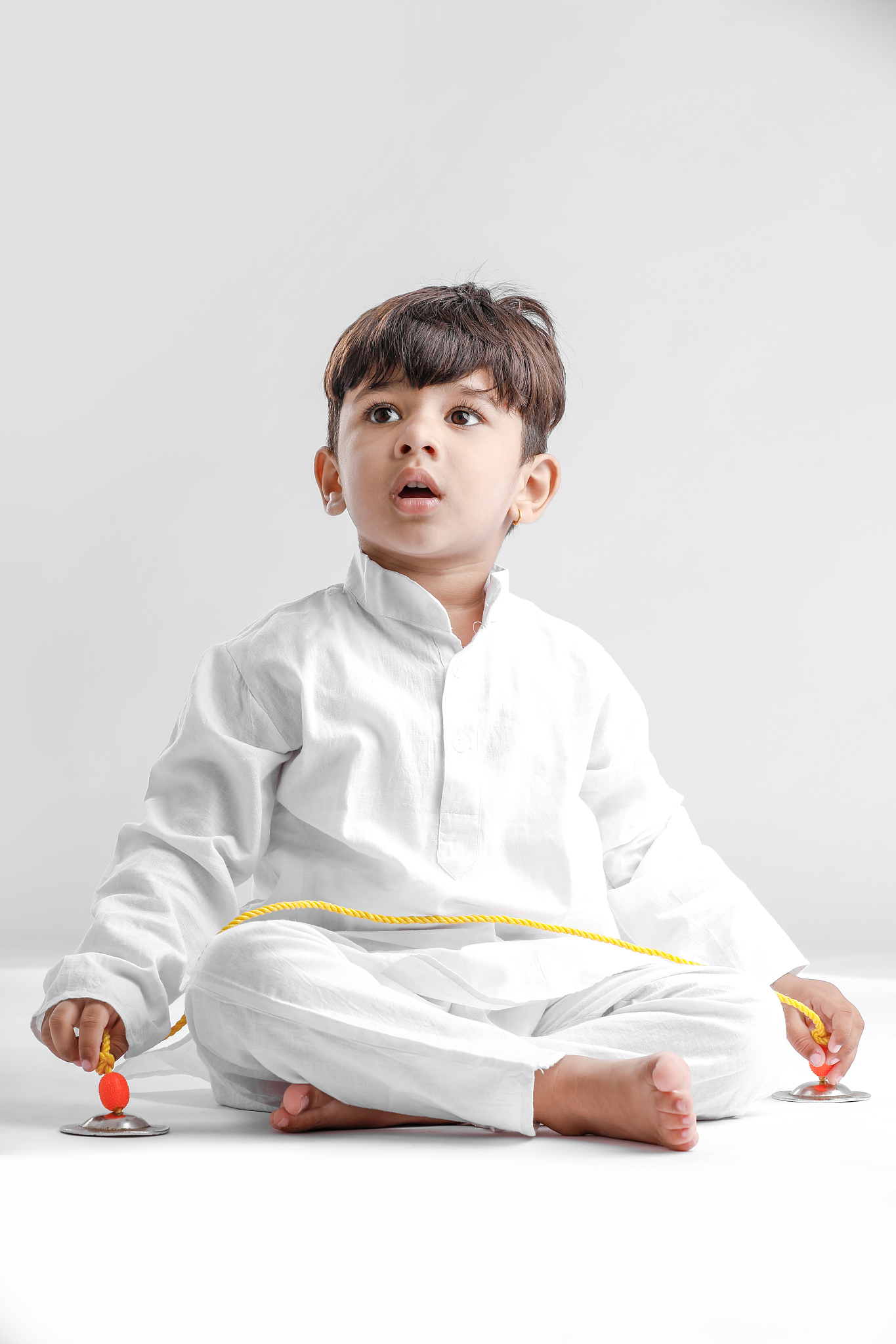 indian little boy in traditional wear and showing multi pal expr