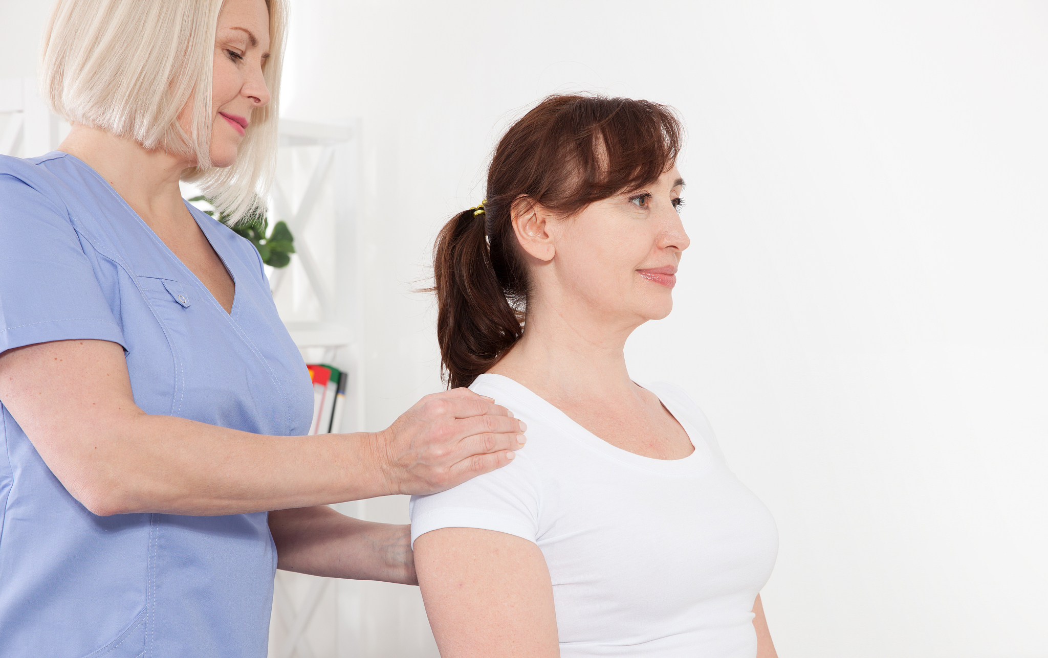 physiotherapist working with middle aged patient in clinic