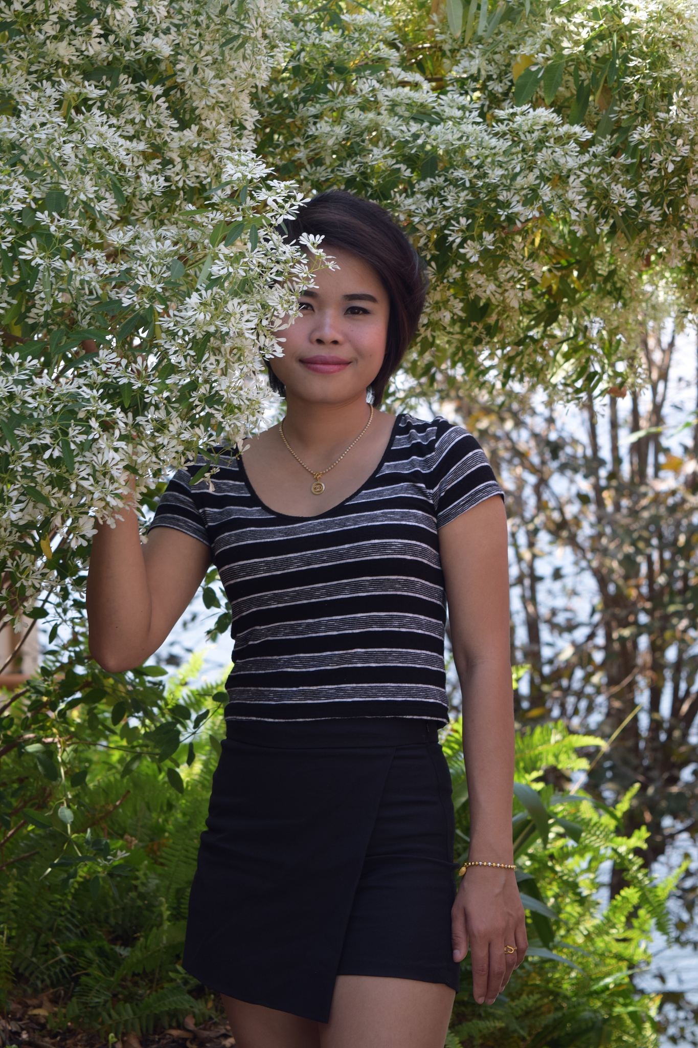portrait of woman standing by flowering plants