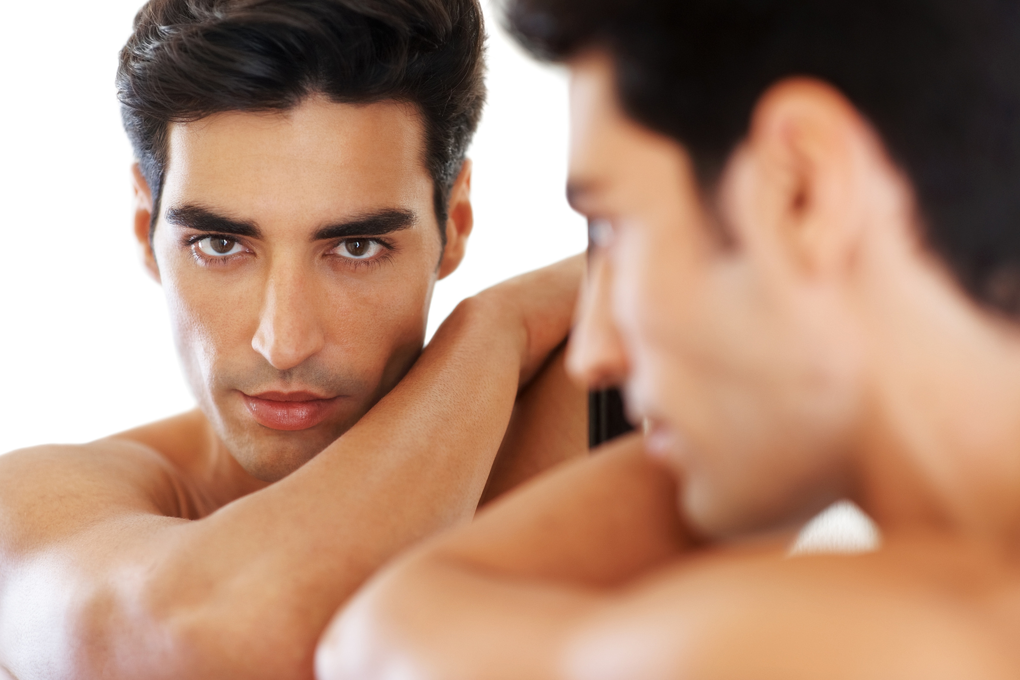 handsome young man looking himself in the mirror