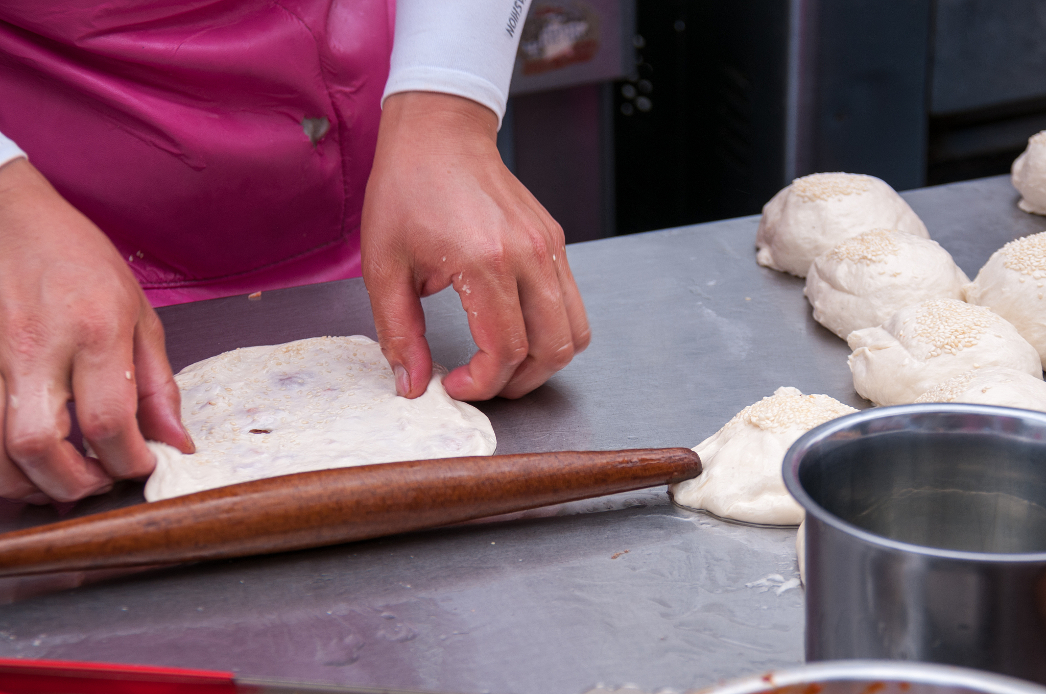 china, heihe, july 2019: a woman rolls dough at the market
