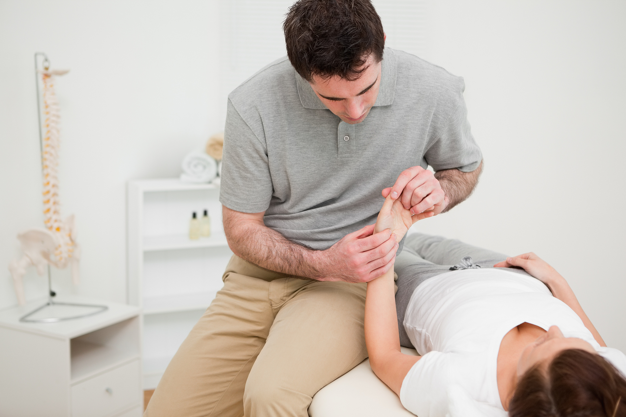physiotherapist looking at the wrist of a patient