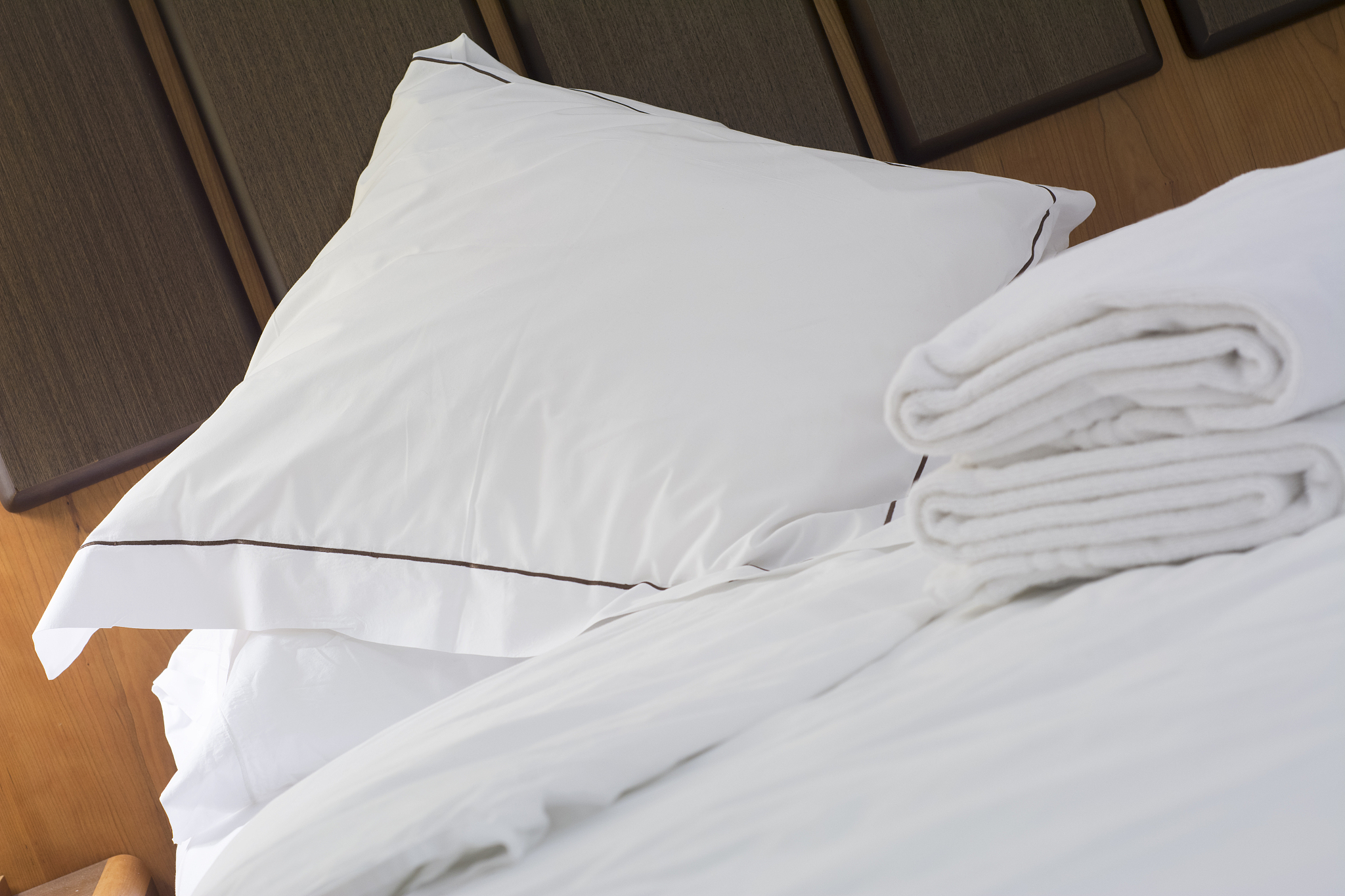 hotel bed pillow and white sheets