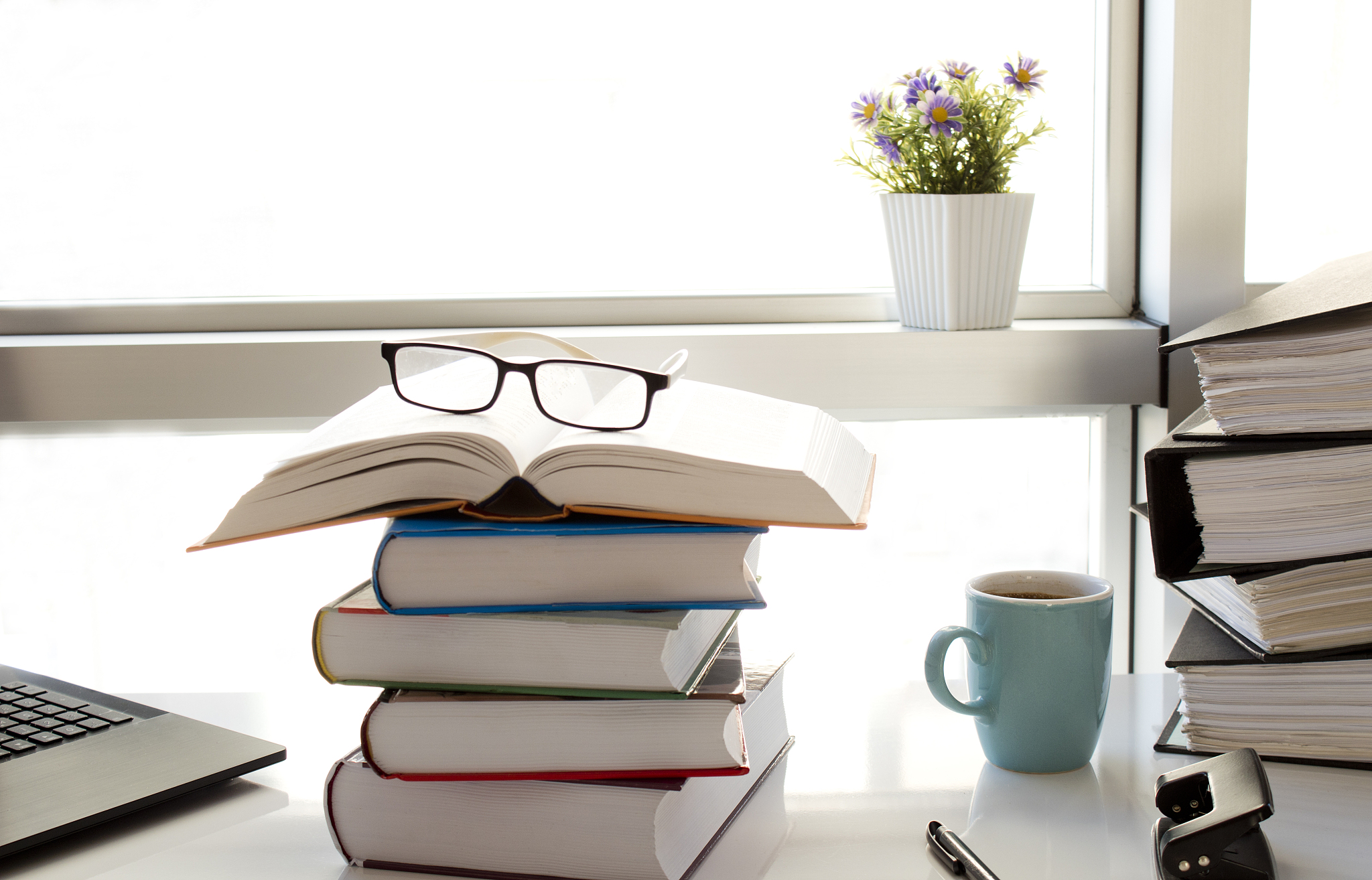 computer and books on white business table.