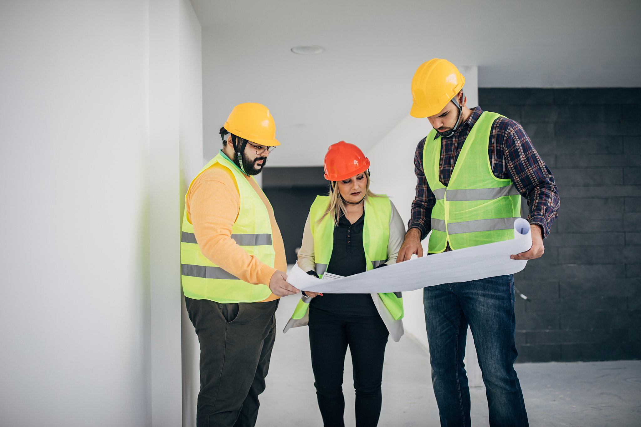 engineers and architects looking at building blueprint at the co