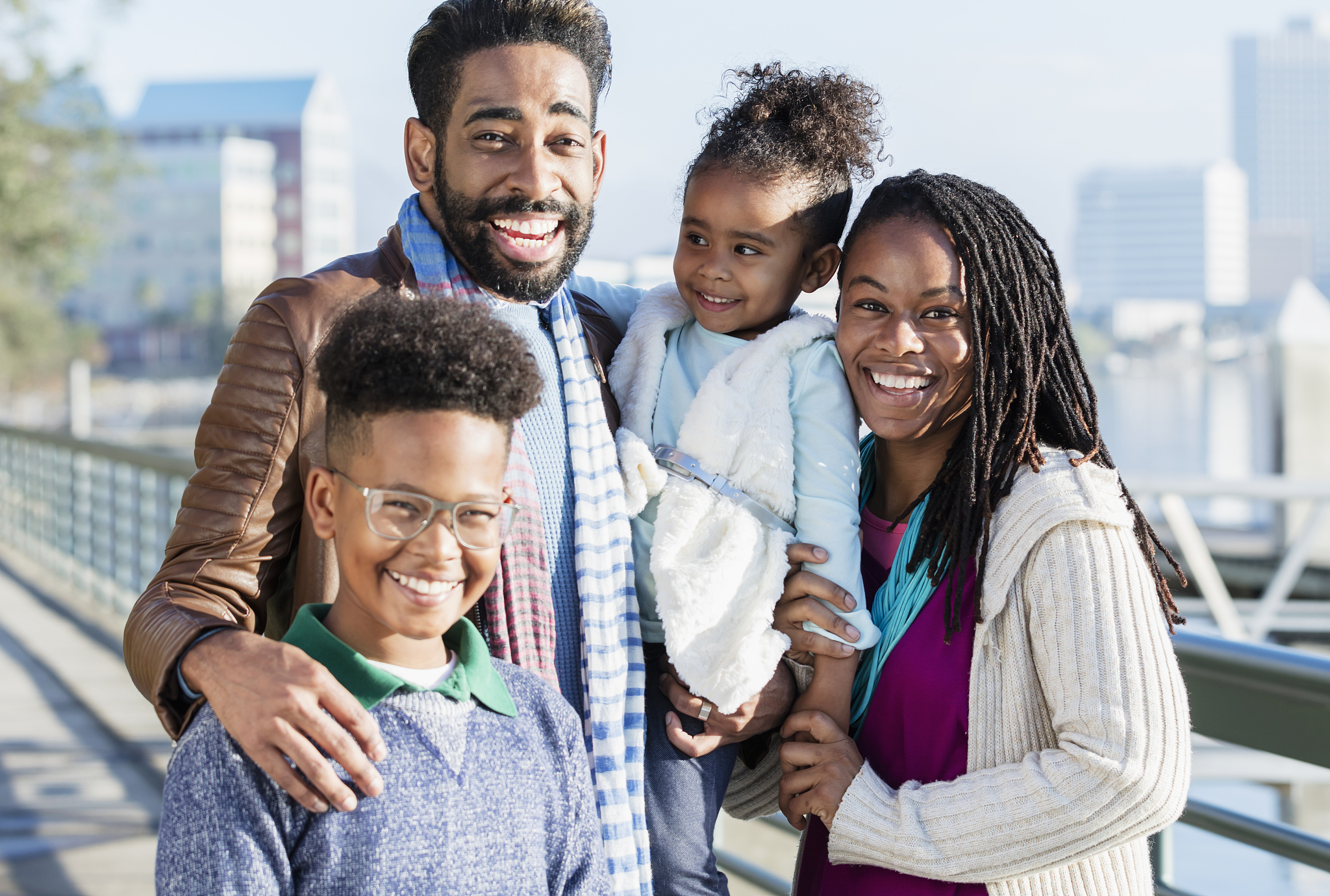 family with two children standing on city waterfront