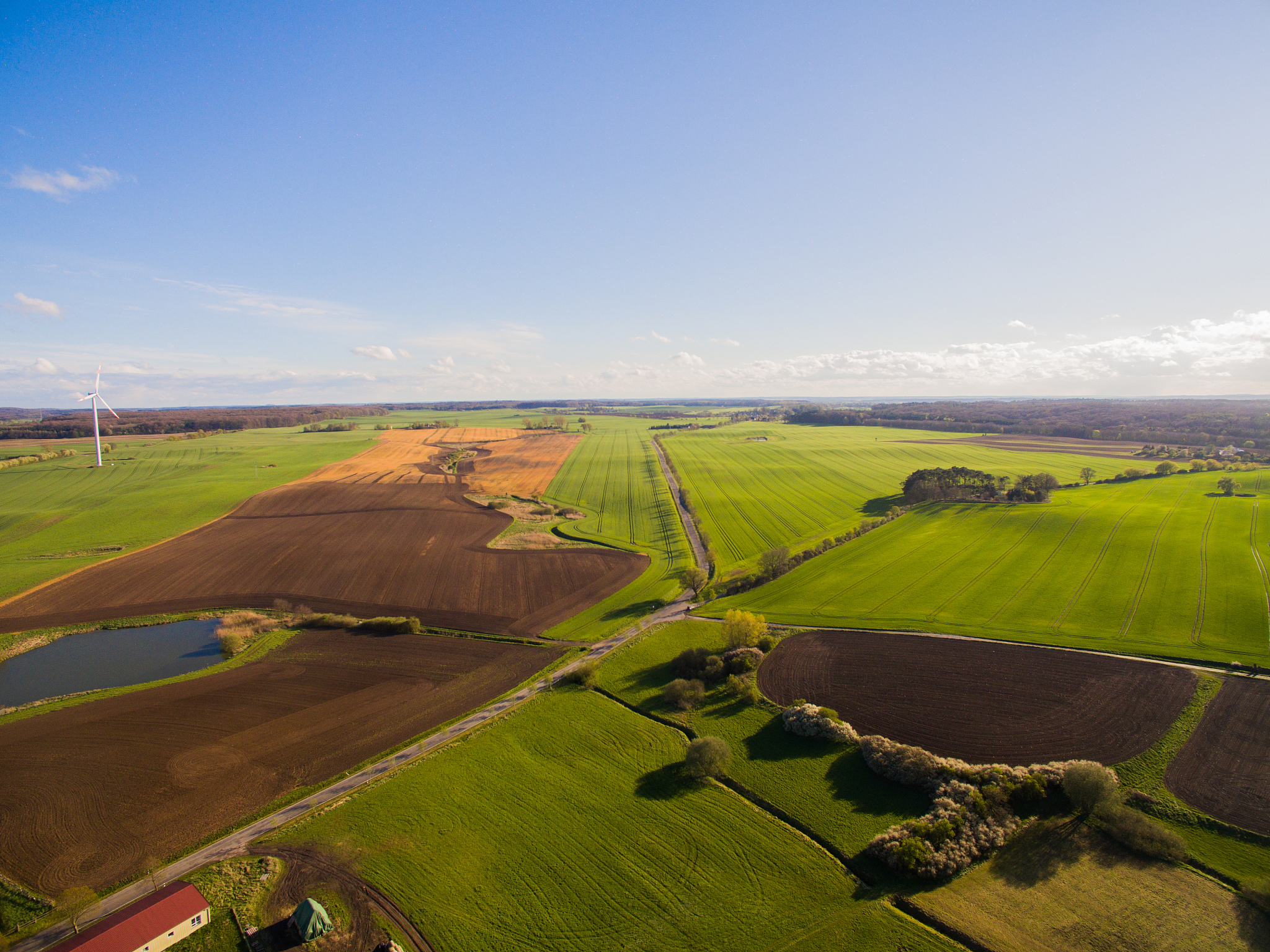 aerial view of beautiful agricultural fields in spring under blu