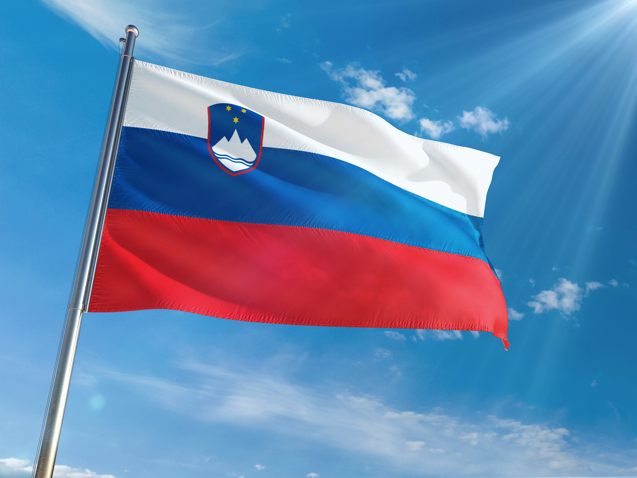 slovenia national flag waving on pole against sunny blue sky bac
