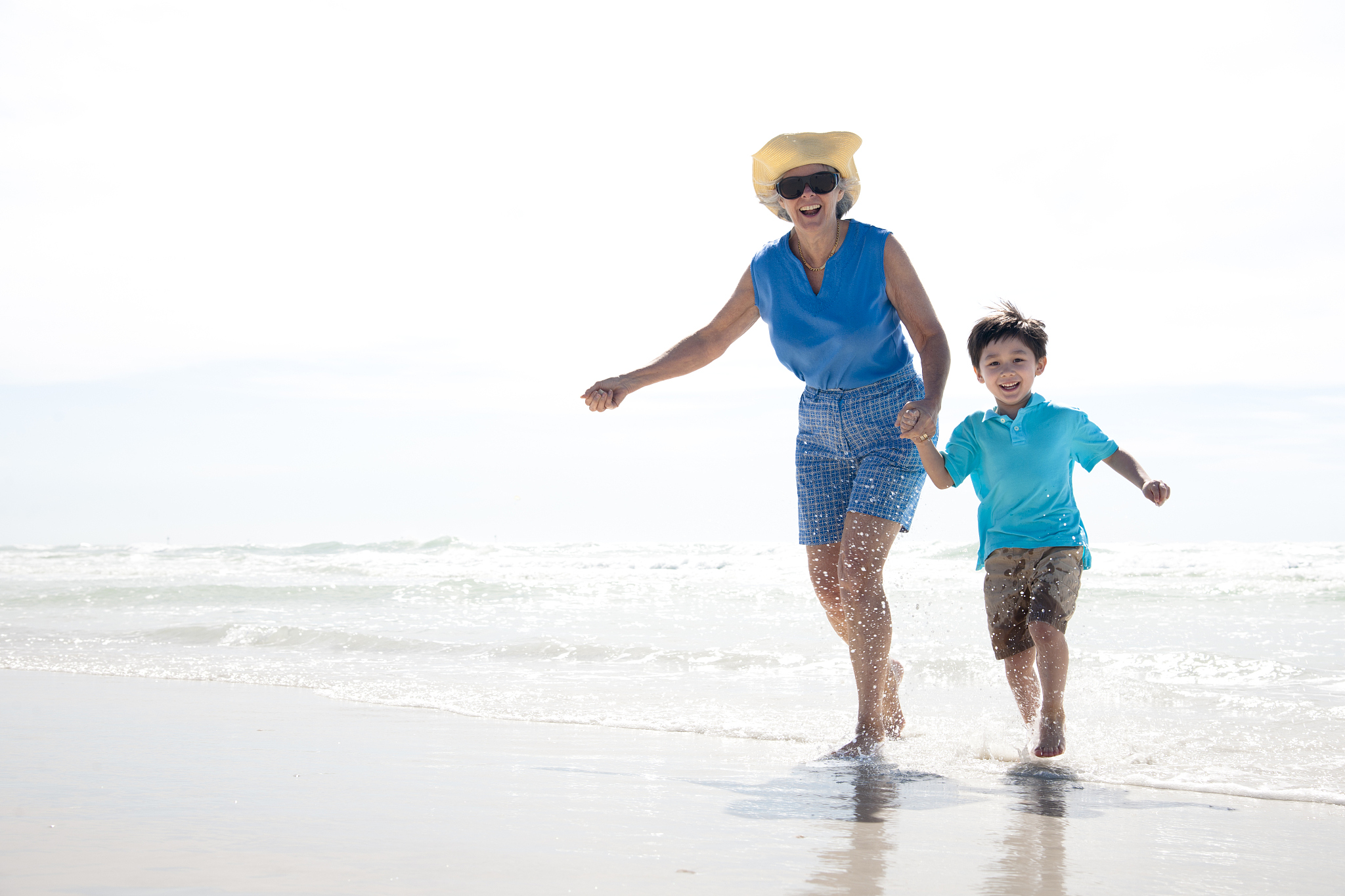 grandmother and grandson running on the beach
