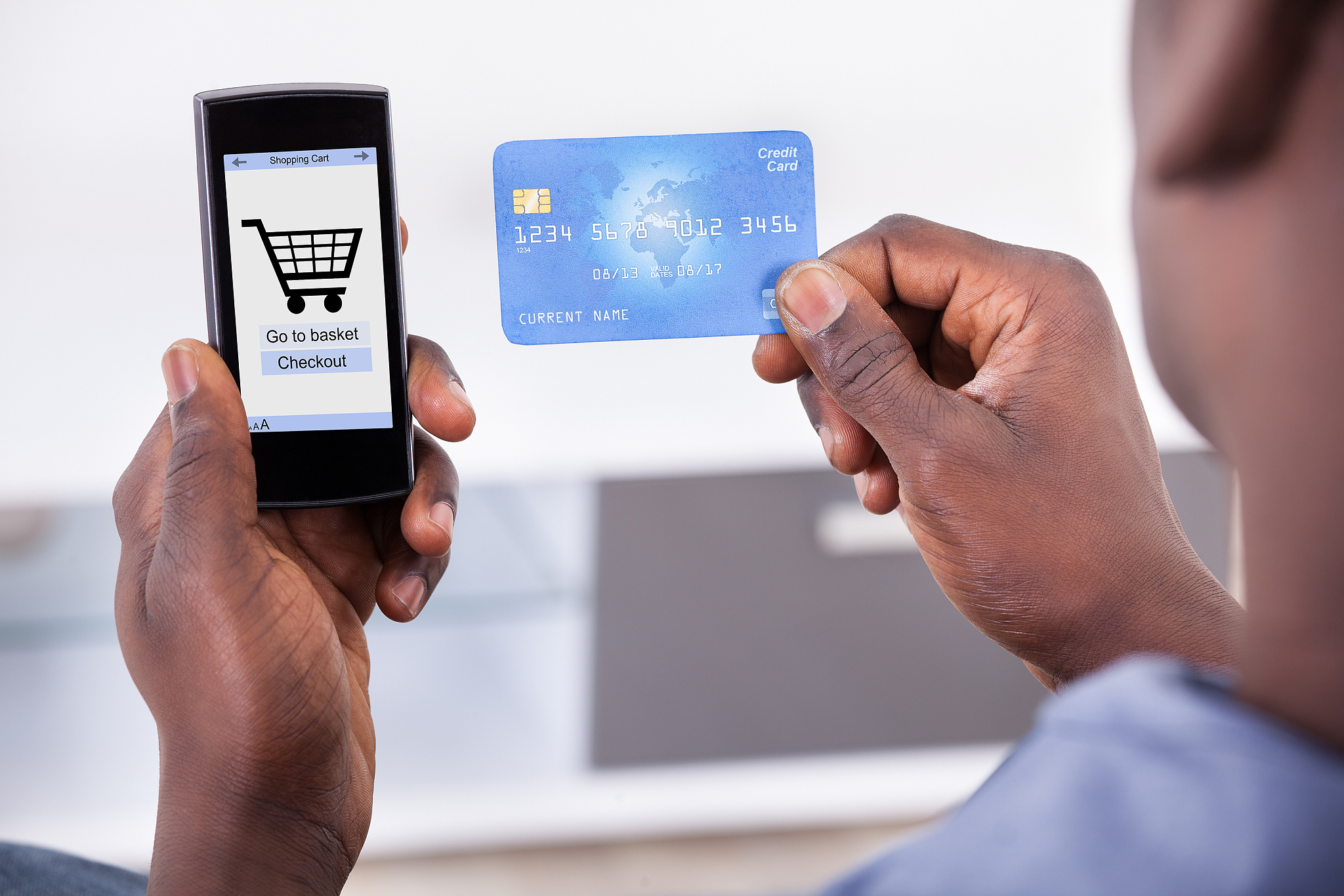 person holding credit card and mobile phone