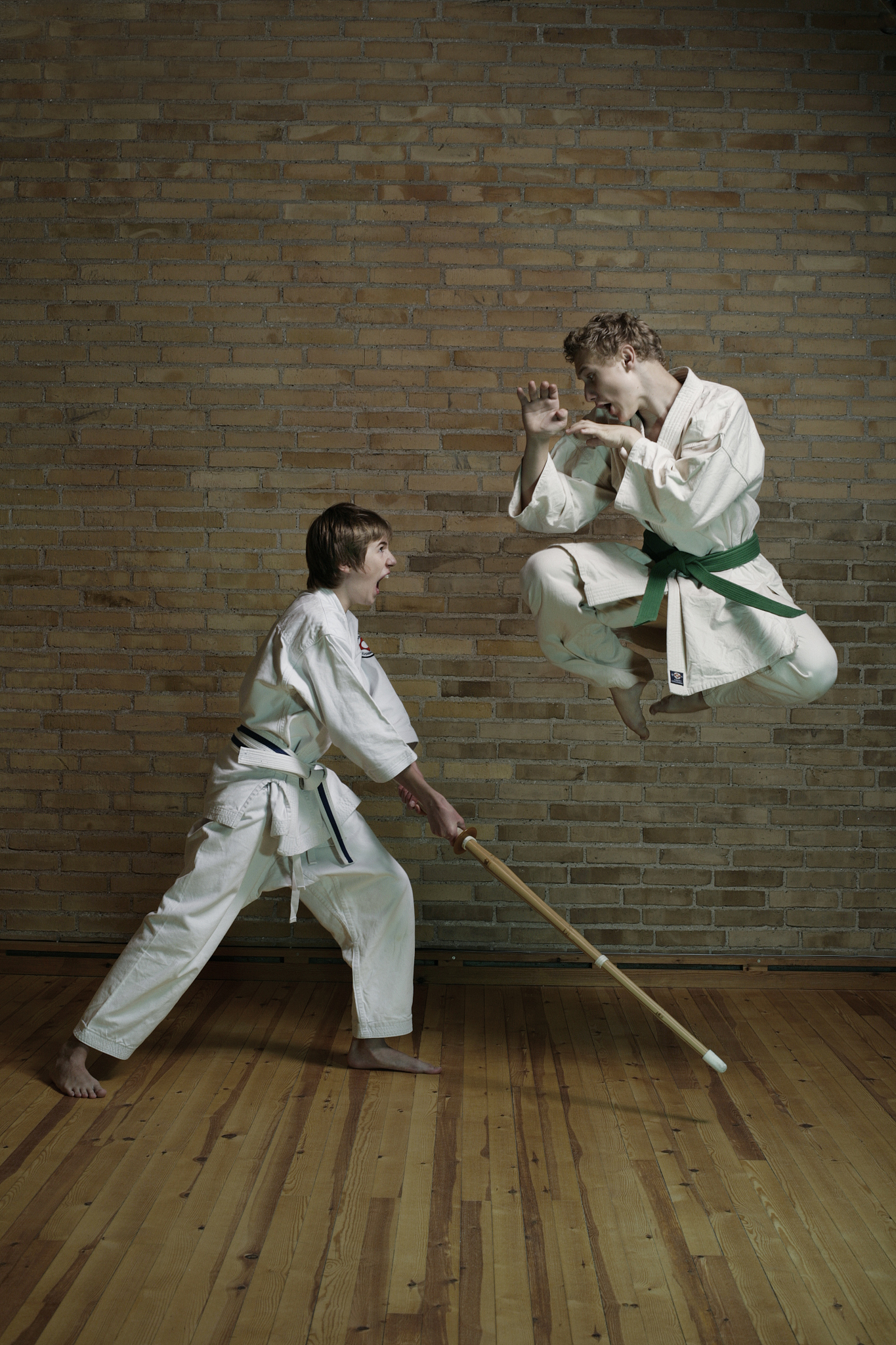 2 boys practicing karate with wooden weapon