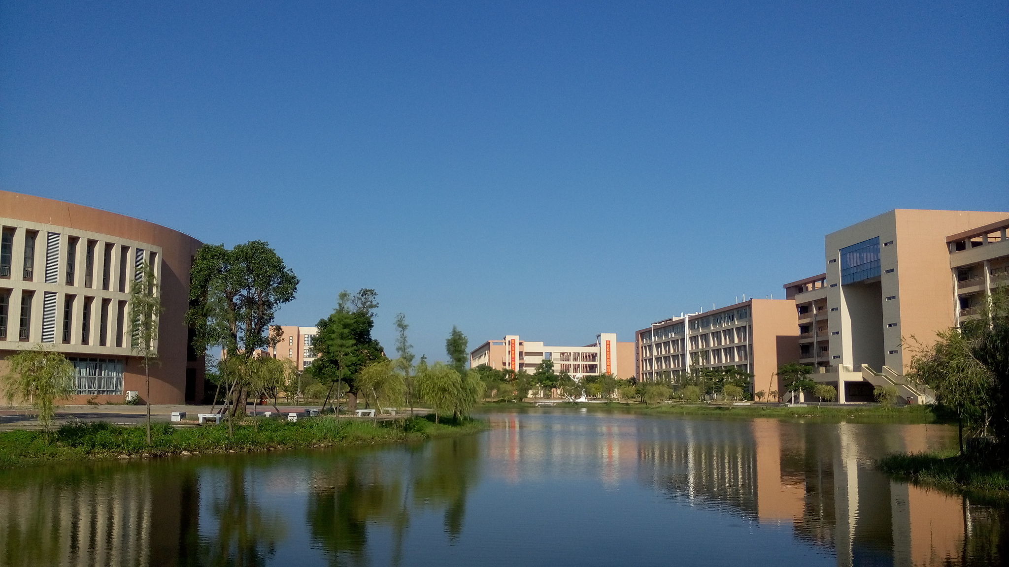 reflection of houses and trees in water against clear blue sky