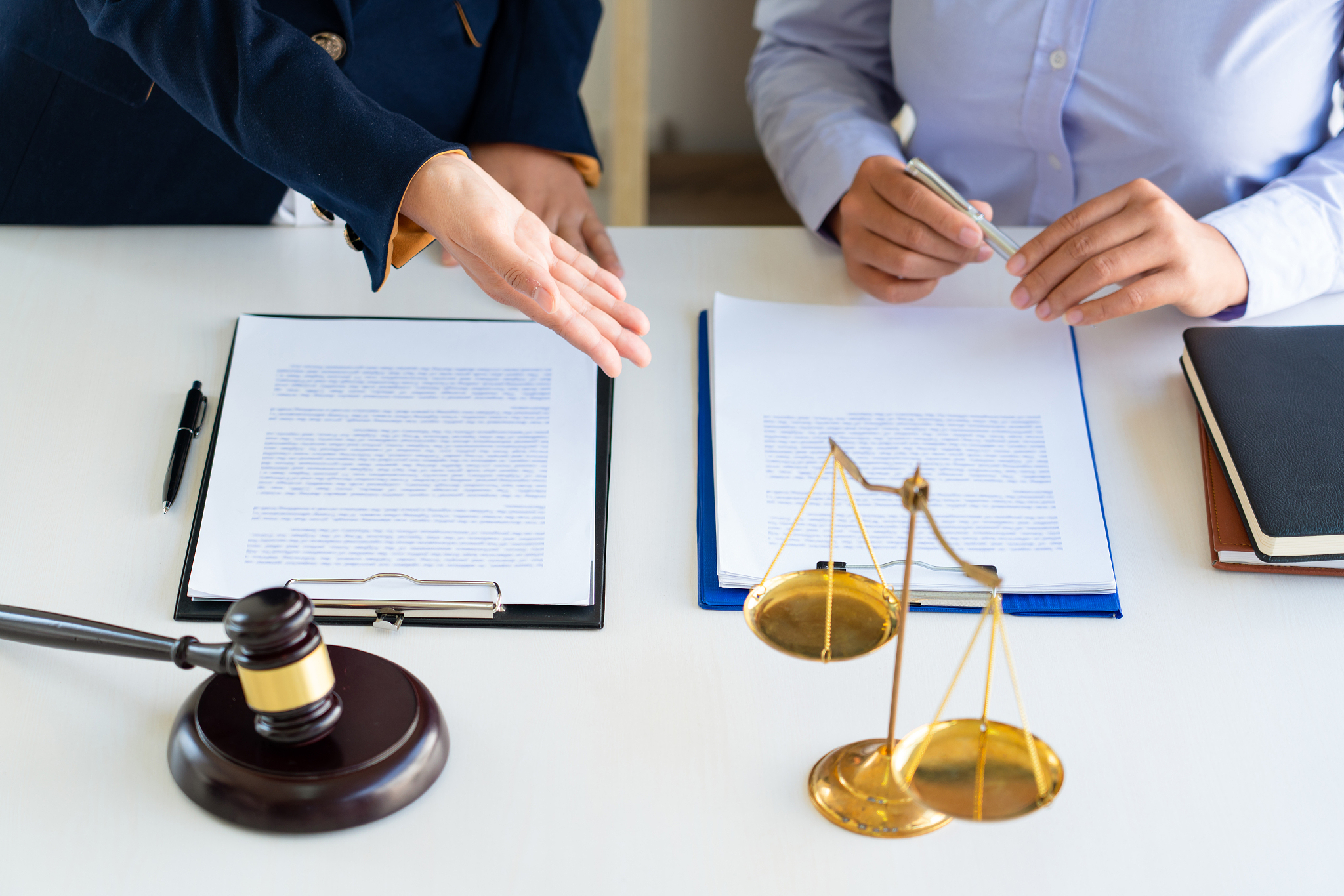 midsection of client and lawyer having discussion in office