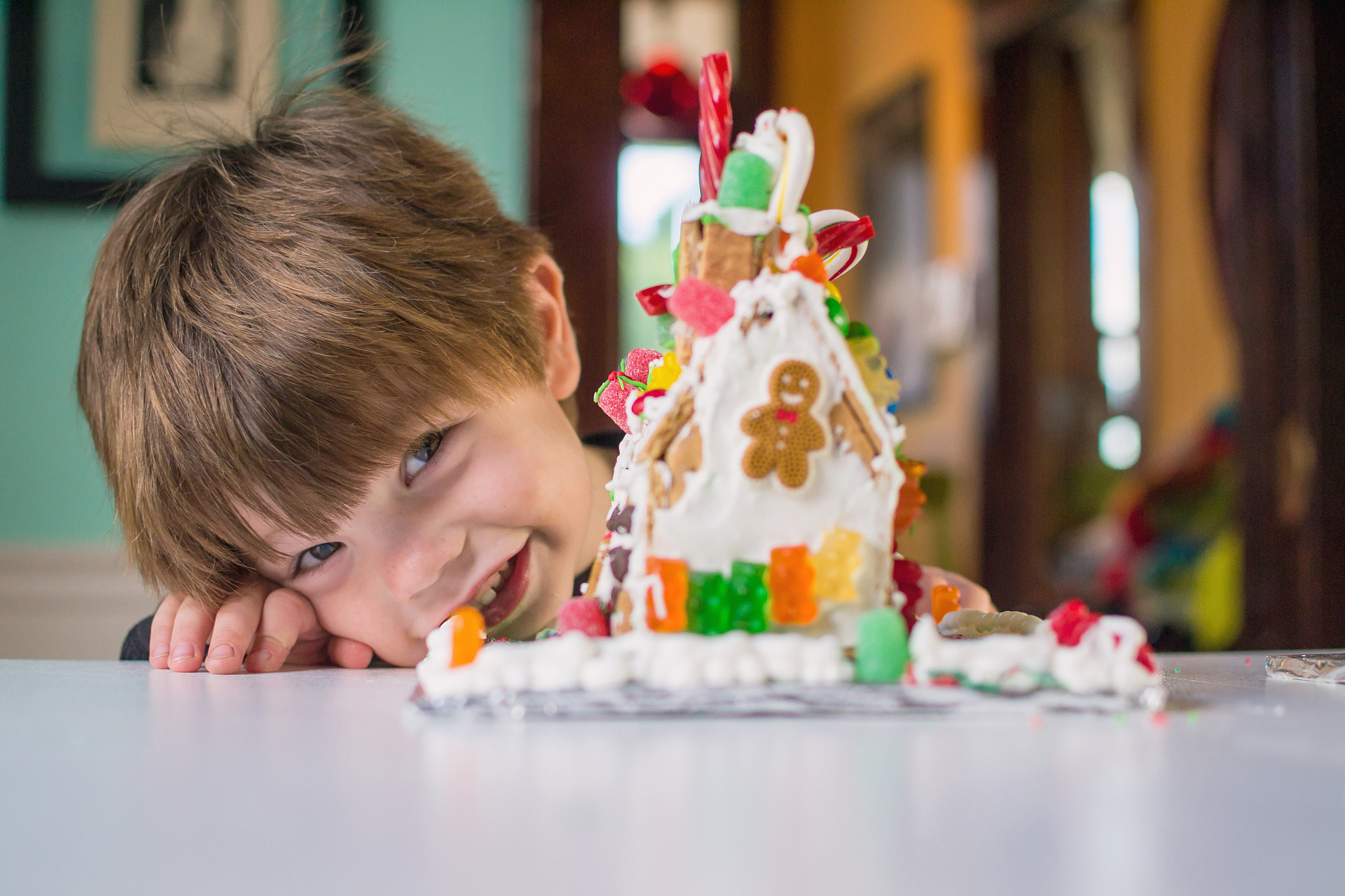 smiling boy with gingerbread house