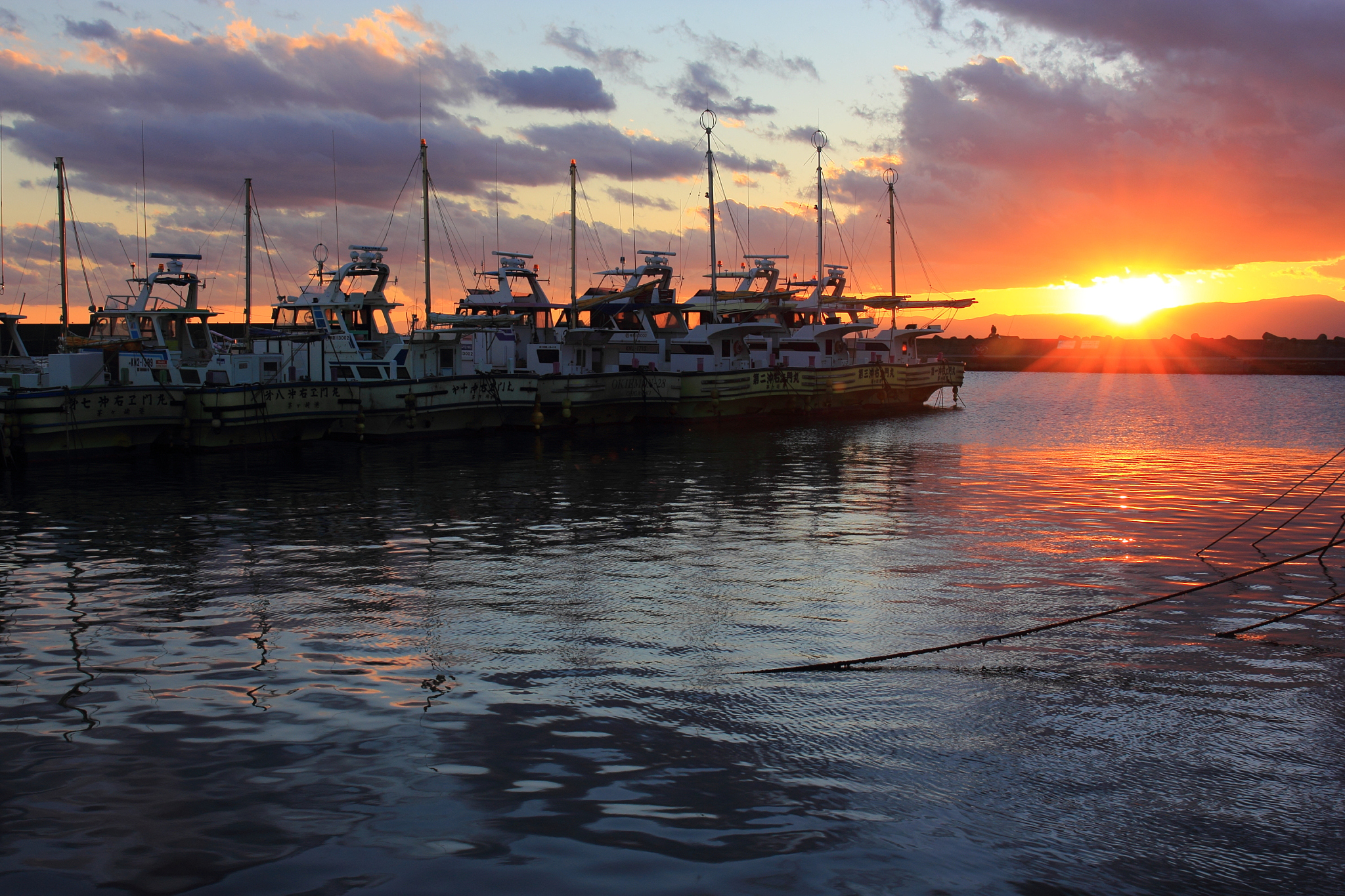 boats moored in lake against sky during sunset