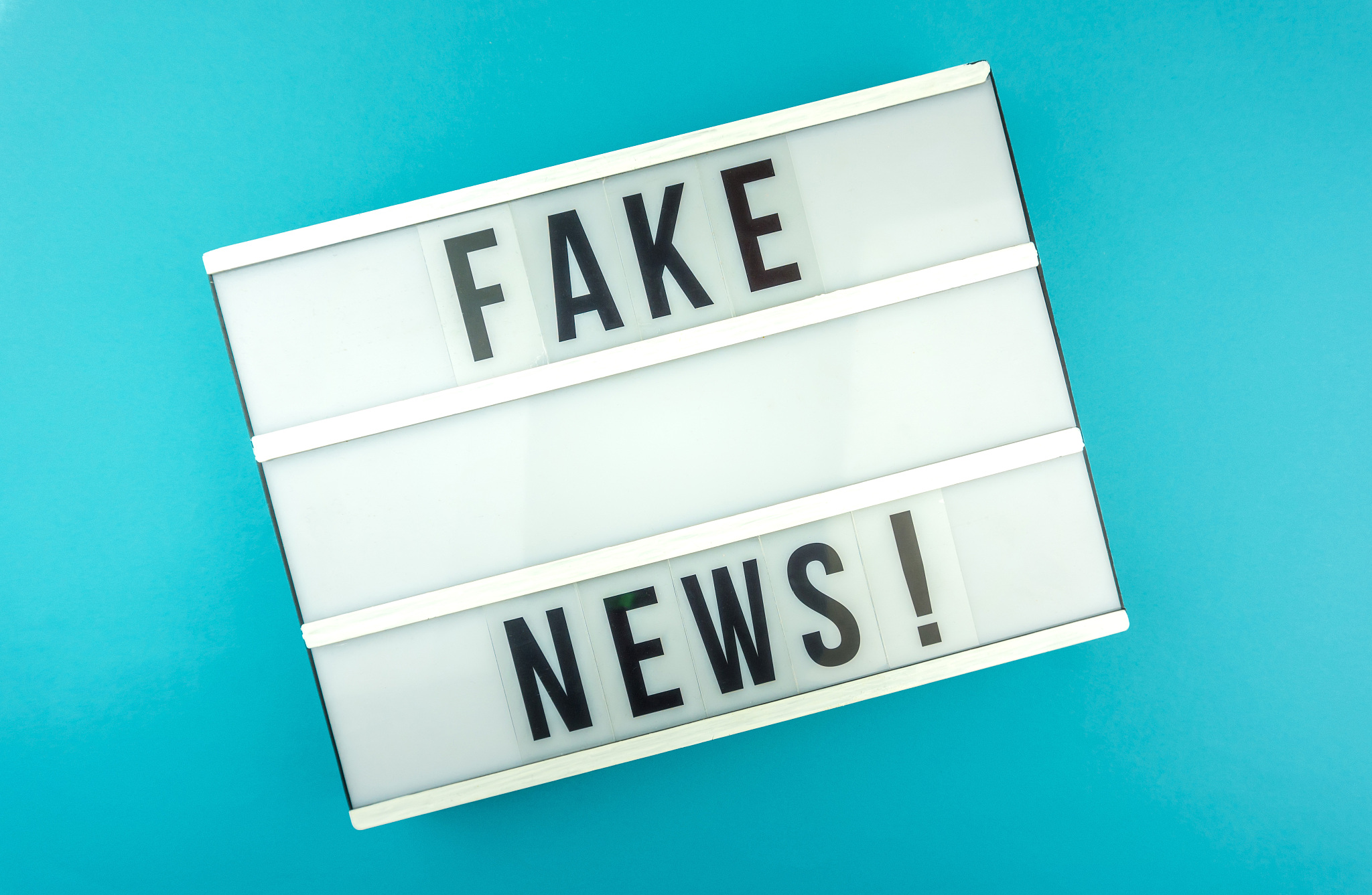 light box with the headline fake news with against blue backgrou
