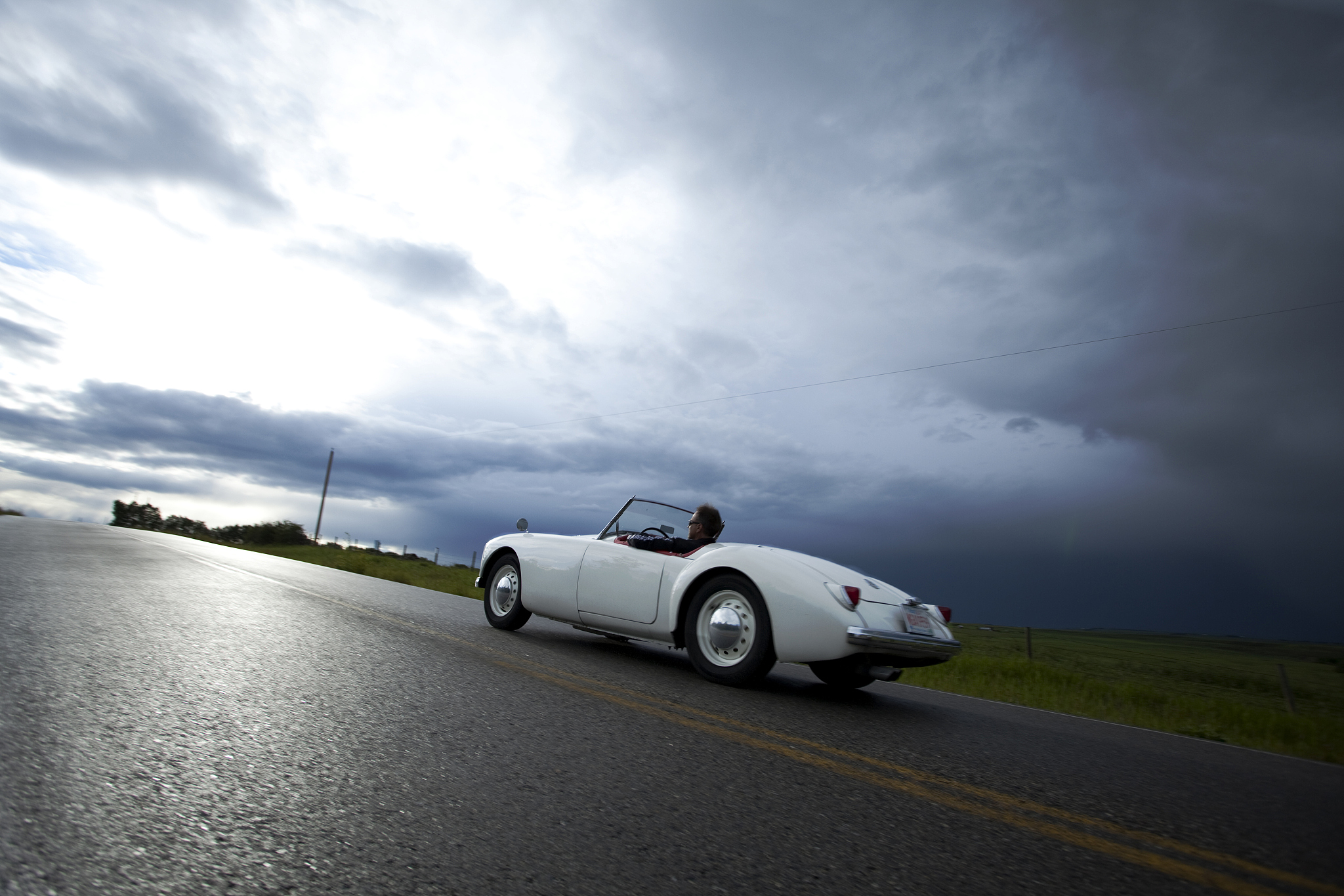 man drives convertible sports car after storm