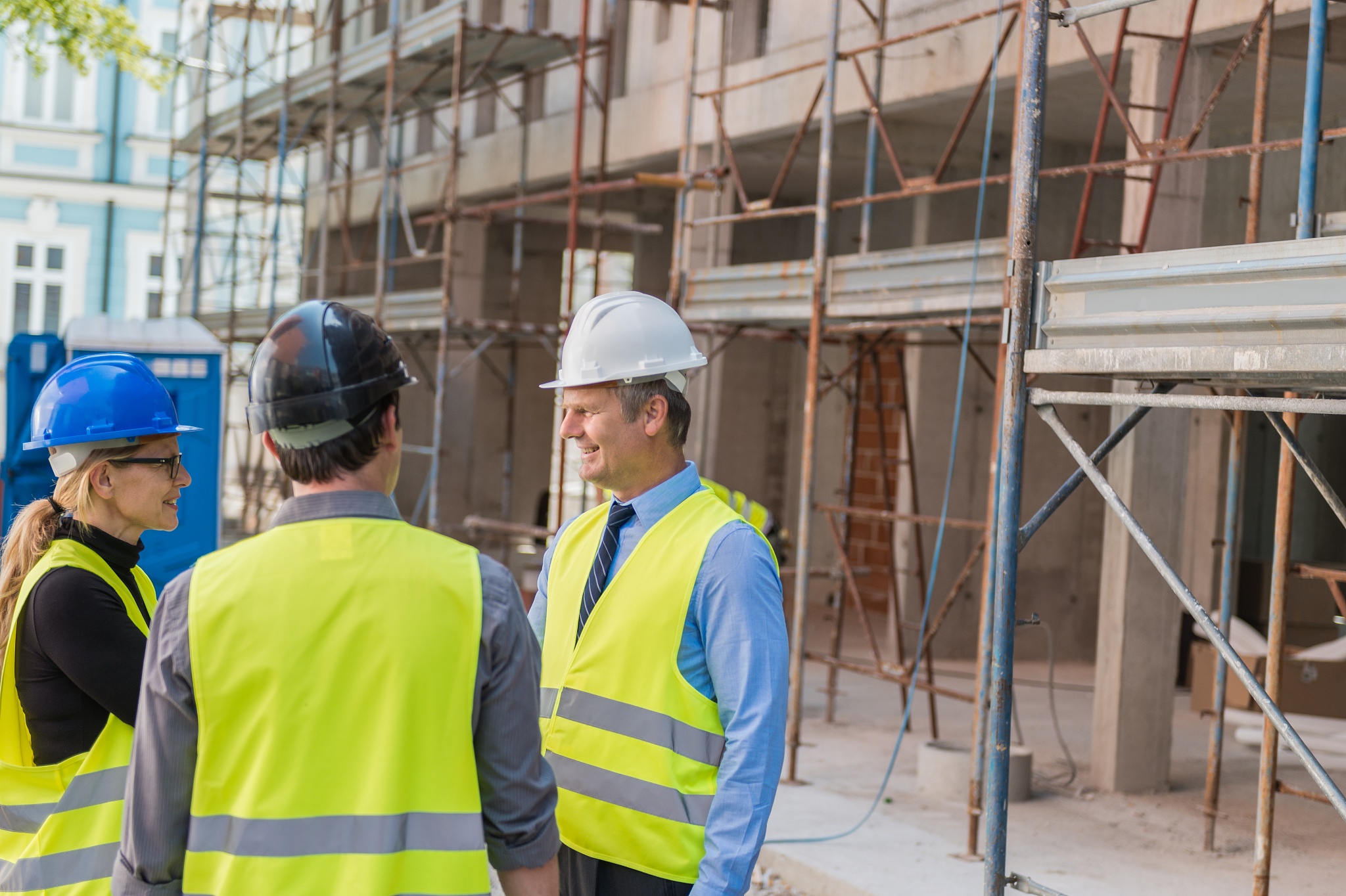 engineer, architect and foreman talking at construction site