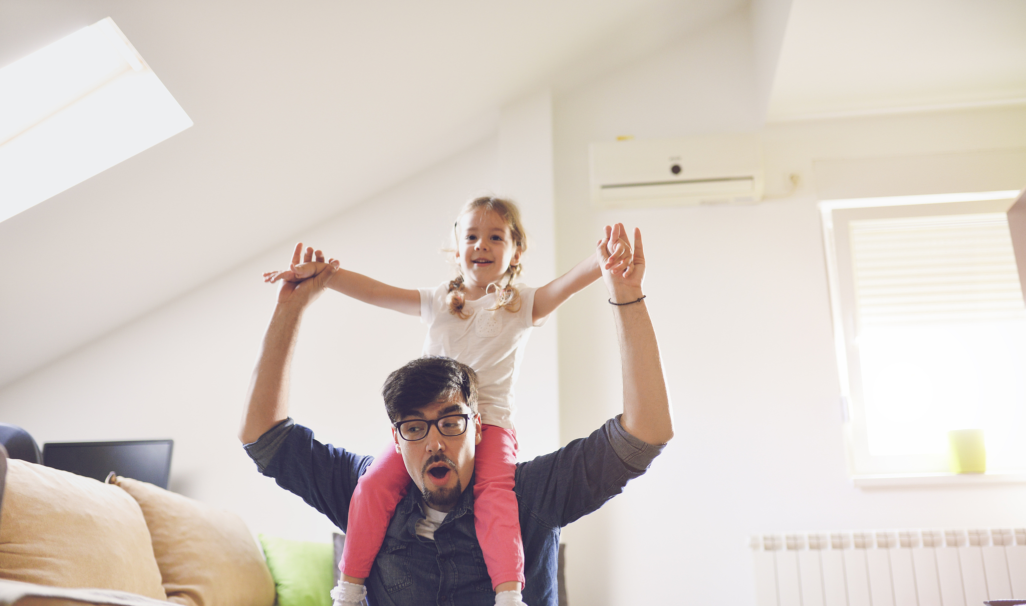little girl climbing onto her father shoulders