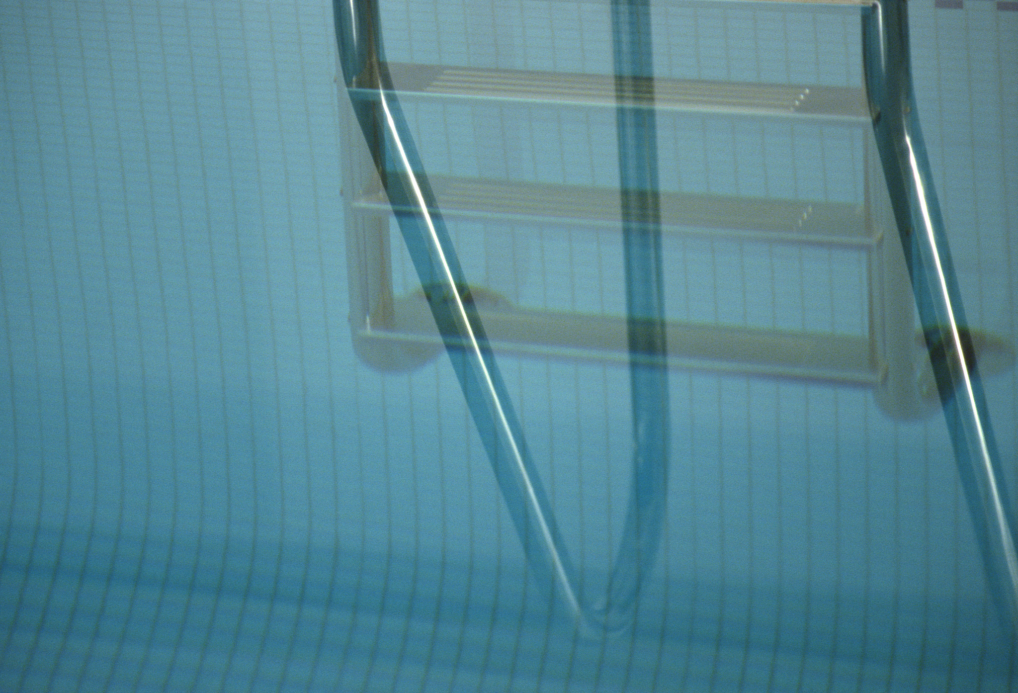 swimming pool tile and ladder reflection