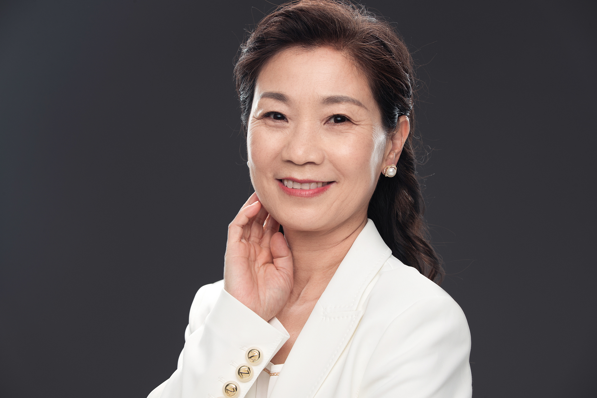用手触摸脸颊的优雅中老年商务女士