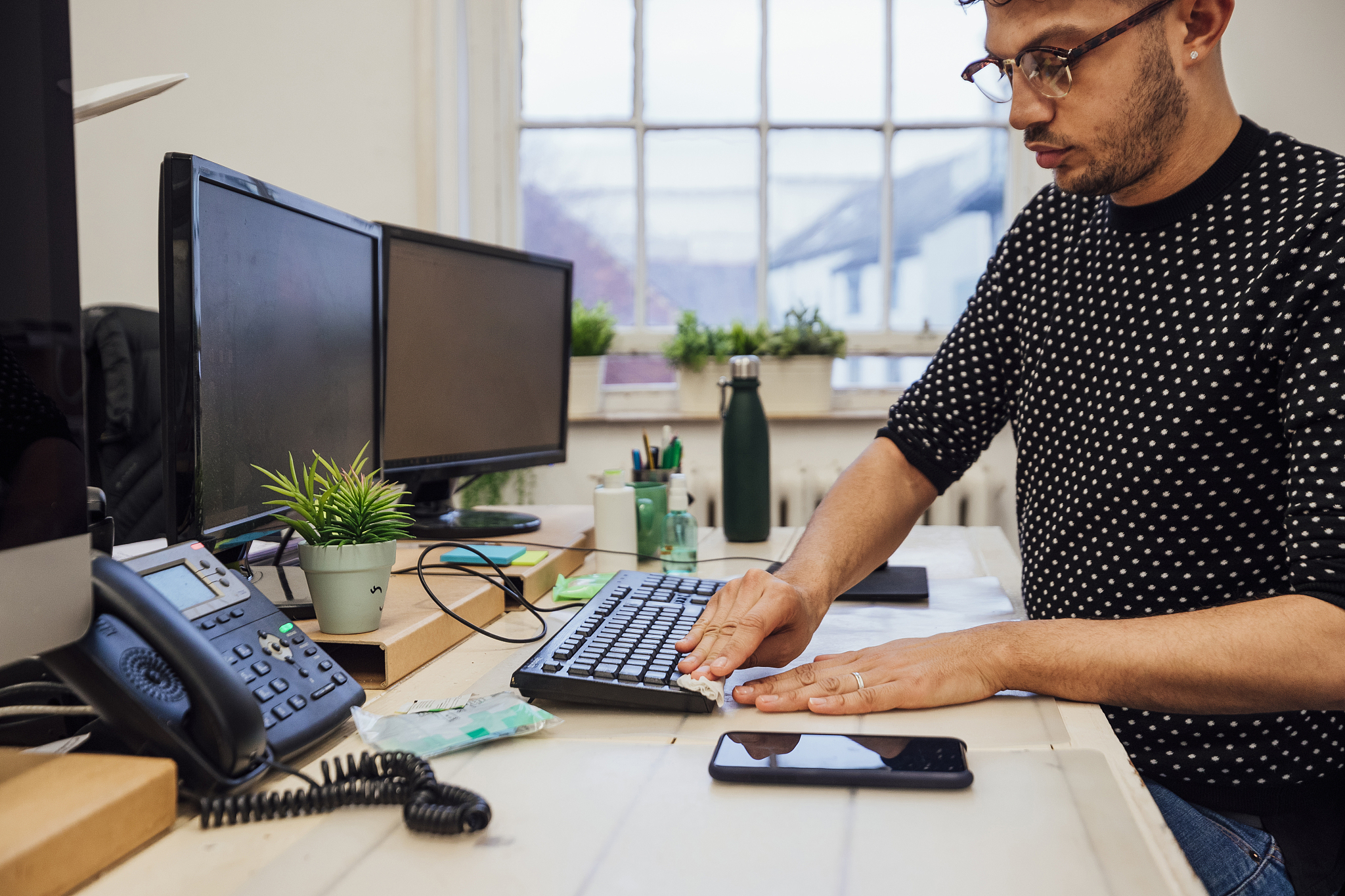 sanitising his workstation