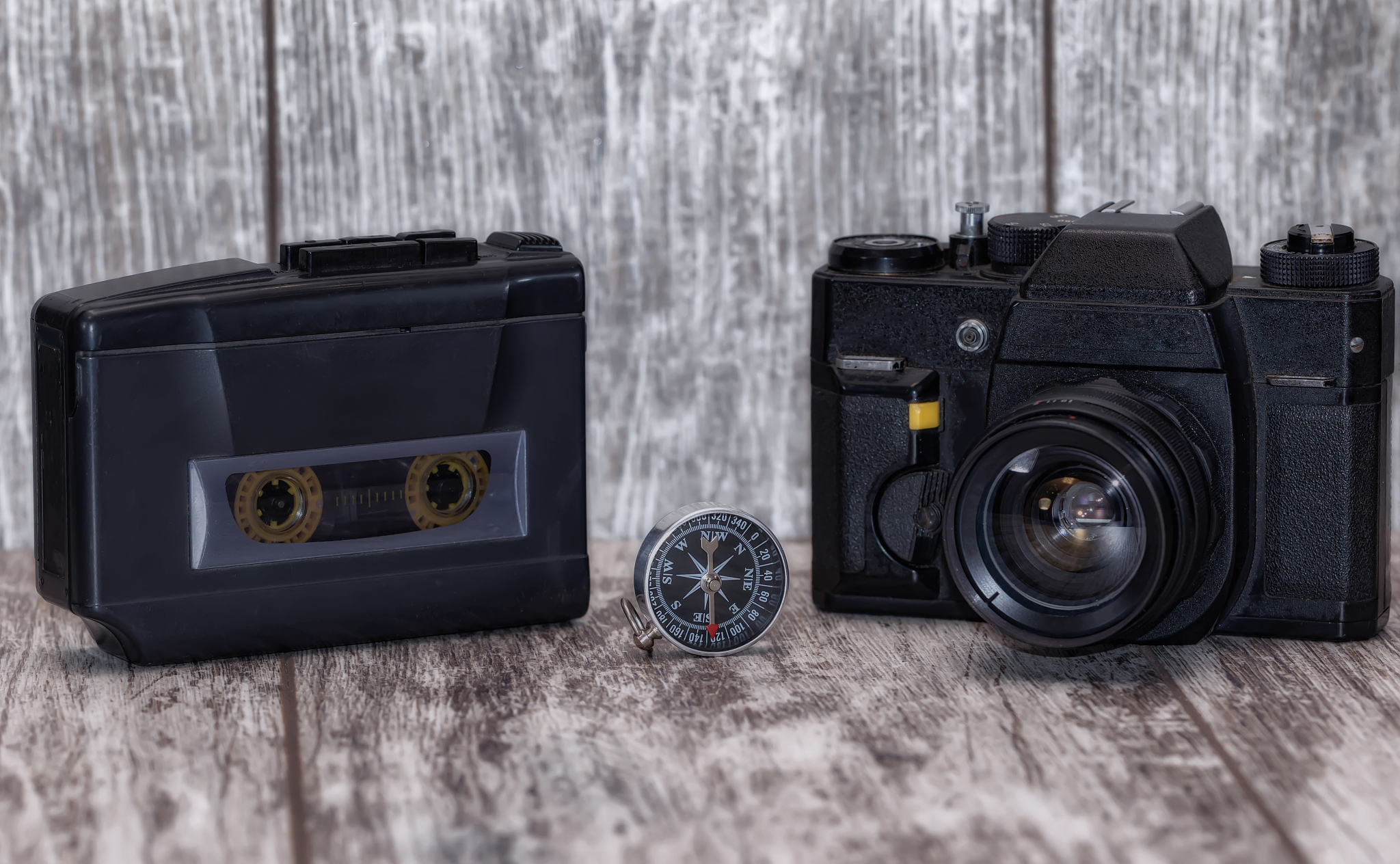 audio cassette player and a film camera on a wooden background