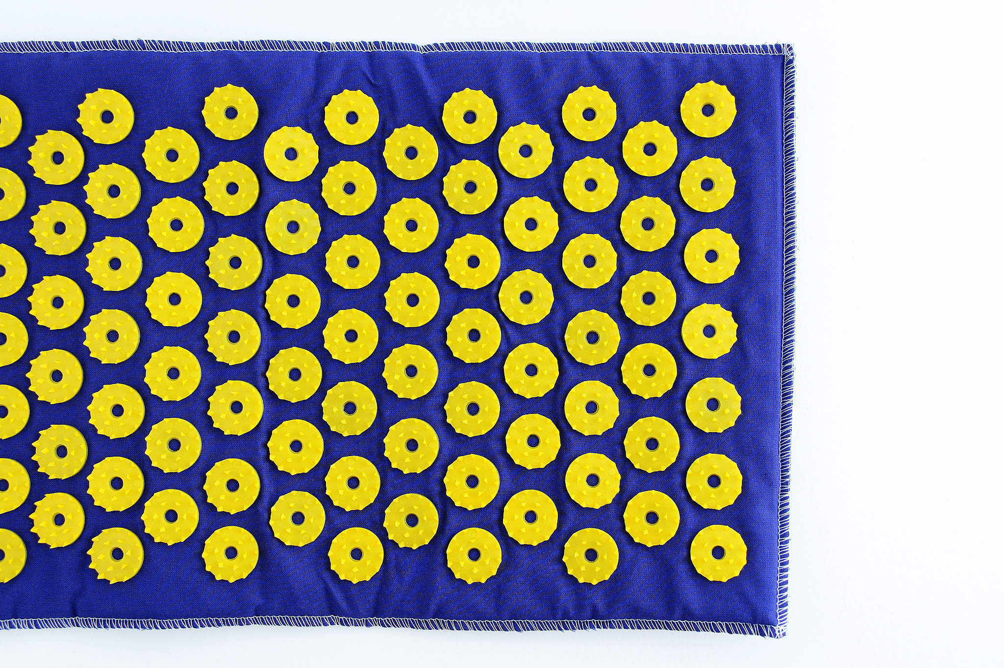 blue massage mat with yellow plastic needles.
